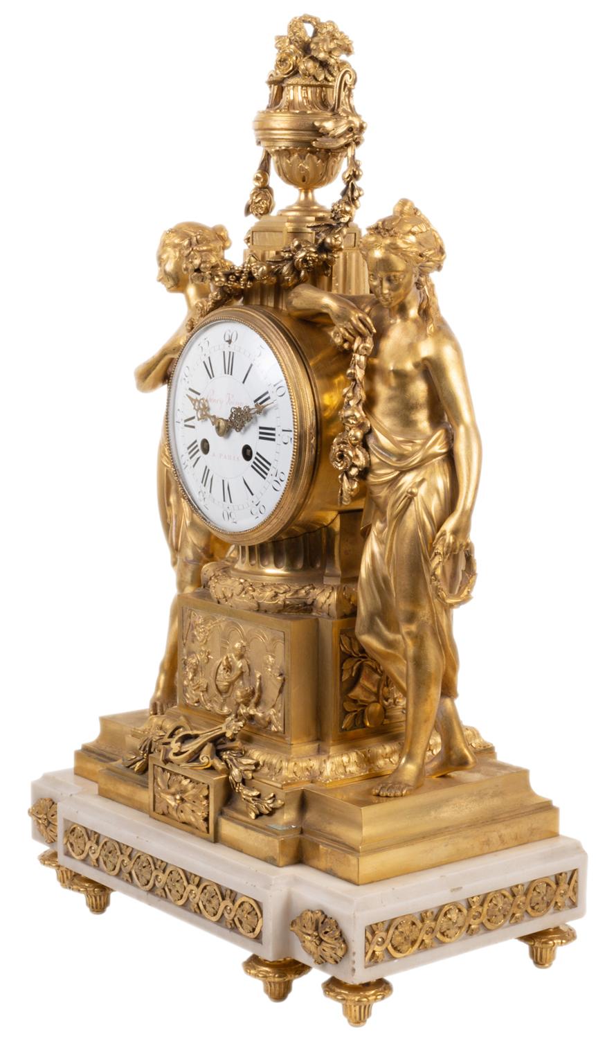 Pendule de cheminée en bronze doré et marbre blanc de style Louis XVI, d'une grande qualité, datant du XIXe siècle. L'horloge en émail blanc, avec un mouvement à carillon d'une durée de huit jours, est posée sur un piédestal à cannelures en bronze