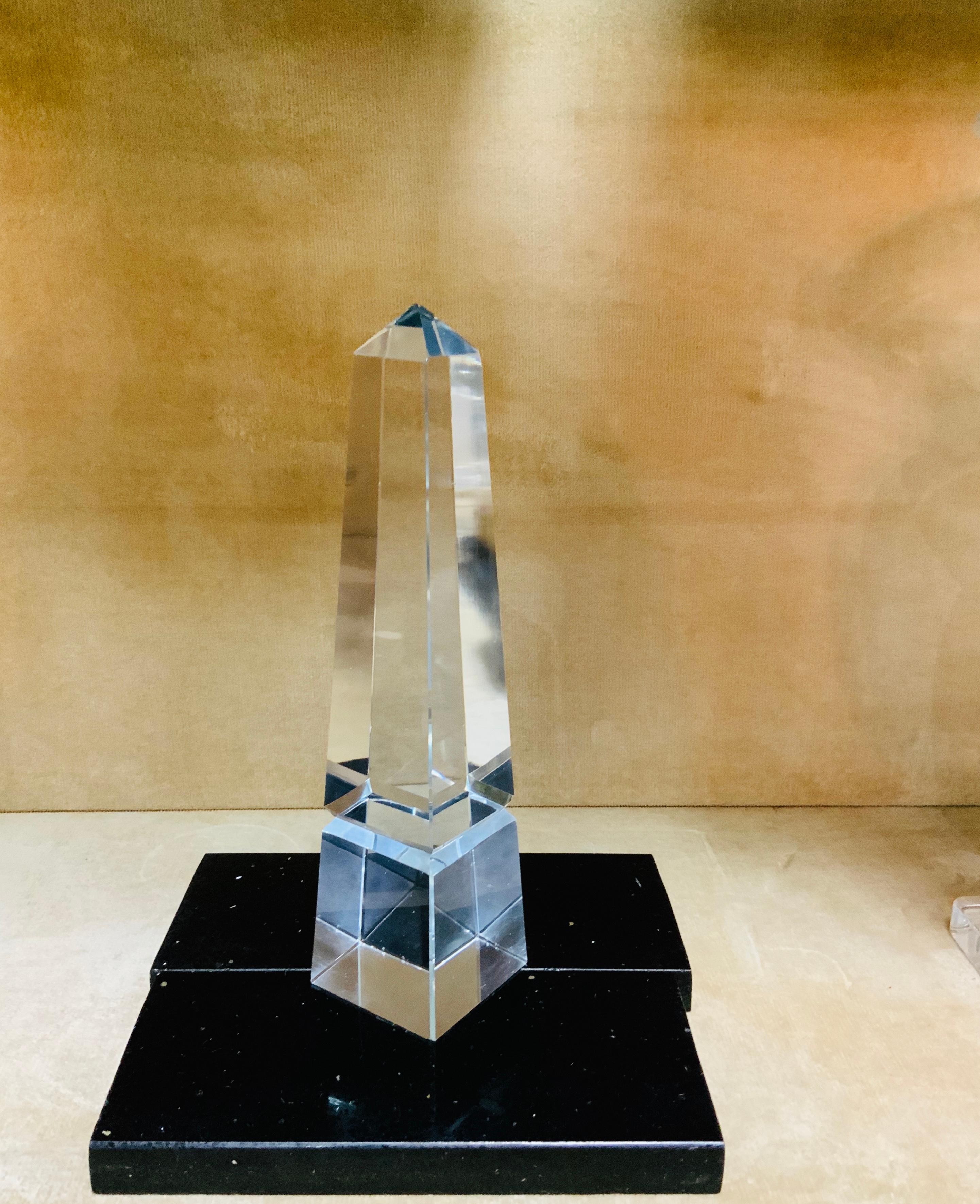 This a large “Louxor” style clear crystal obelisk that ends in a square base. The black marble base is not included.