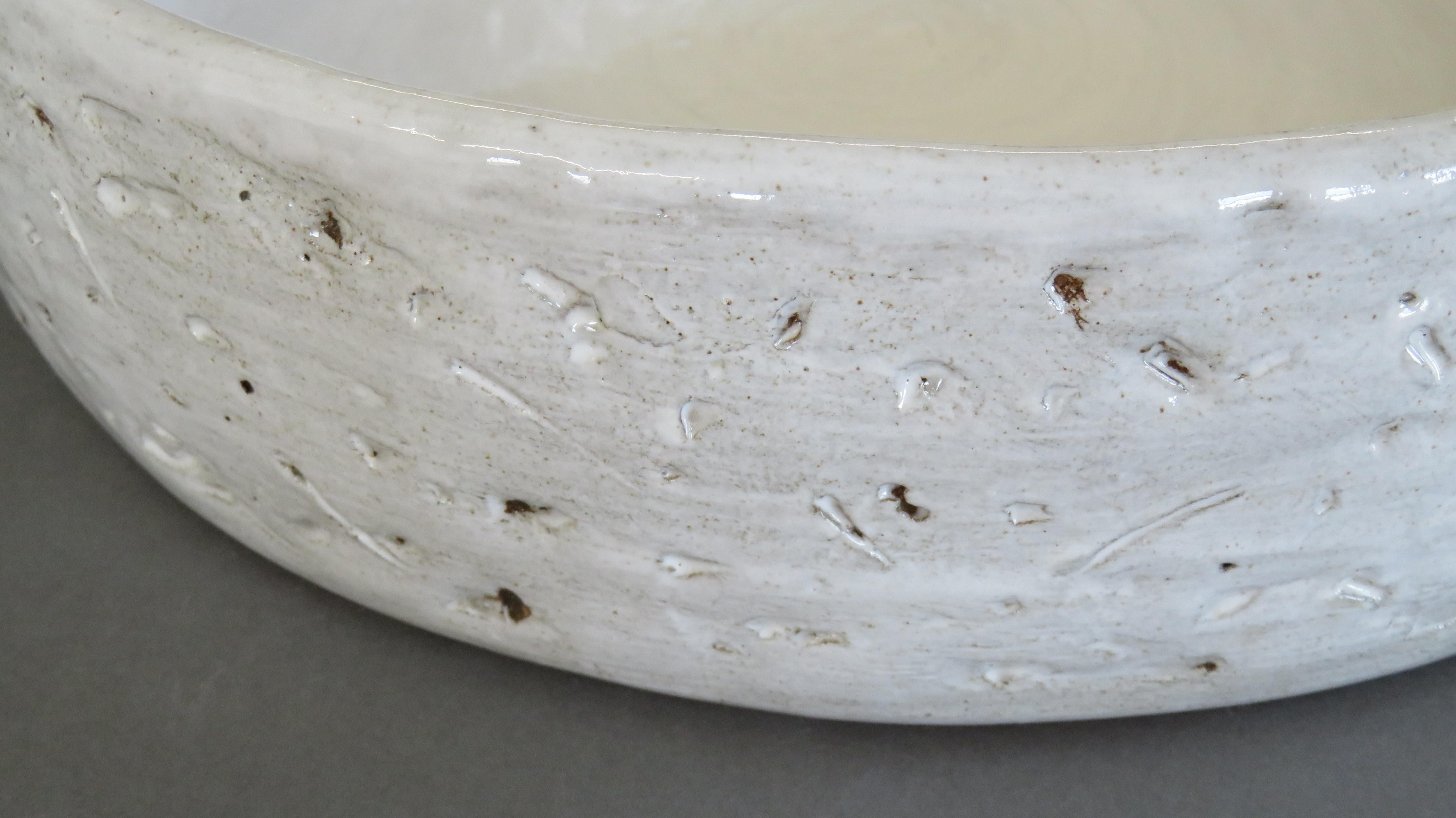 Large, wide and low ceramic stoneware serving bowl.  13.75 inches in diameter.
Subtle hand carved markings on the exterior with rich creamy white glaze.  Underglaze on the bottom reveals variations in the clay and unique firing marks.  Fully