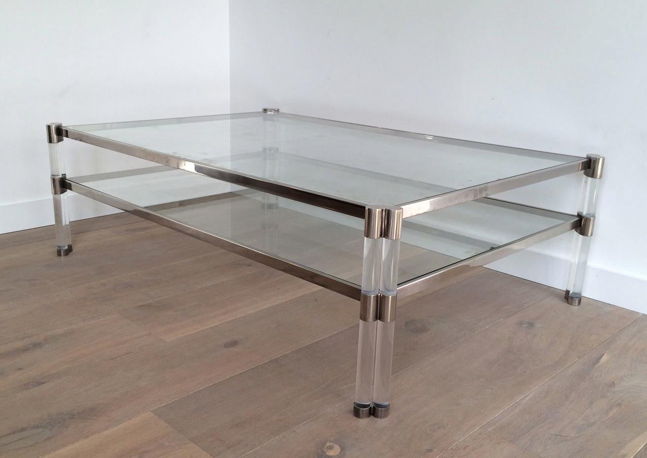 Cette très belle table basse de grande taille est en chrome avec des pieds doubles en lucite et avec 2 étagères en verre. Il s'agit d'une œuvre française. Circa 1970