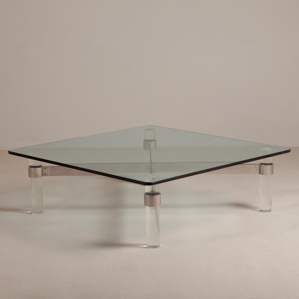 Large Lucite cylindrical legged coffee table with chromium steel cross bar attached to the legs and a glass top, 1970s.
