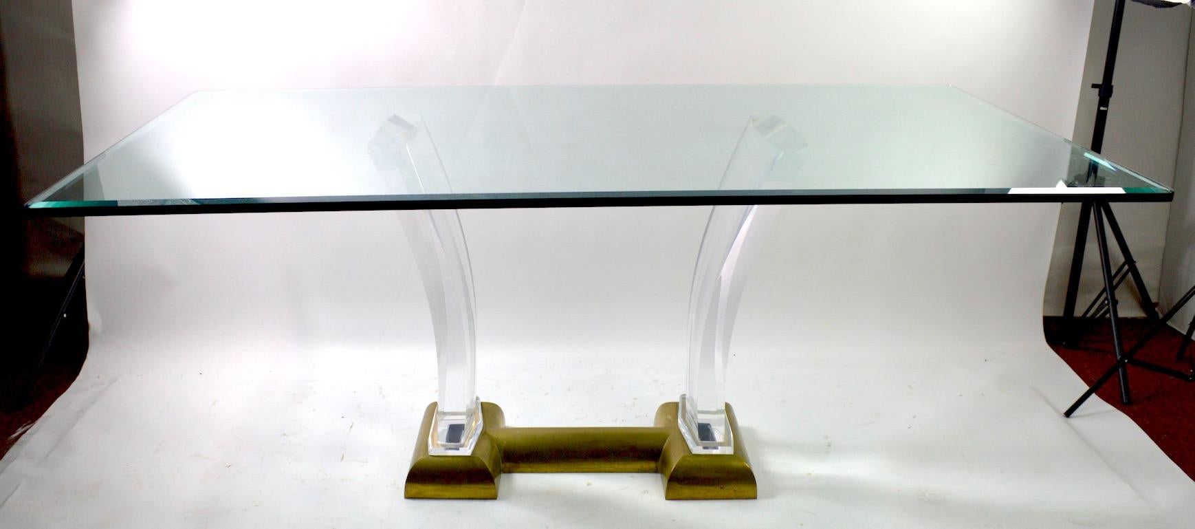 Wonderful Lucite and brass based glass top dining table by Jeffrey Bigelow. Exuberant 1980's Art Deco Revival, Hollywood Regency style in original, clean ready to use condition. The brass base shows patination, normal and consistent with age. The