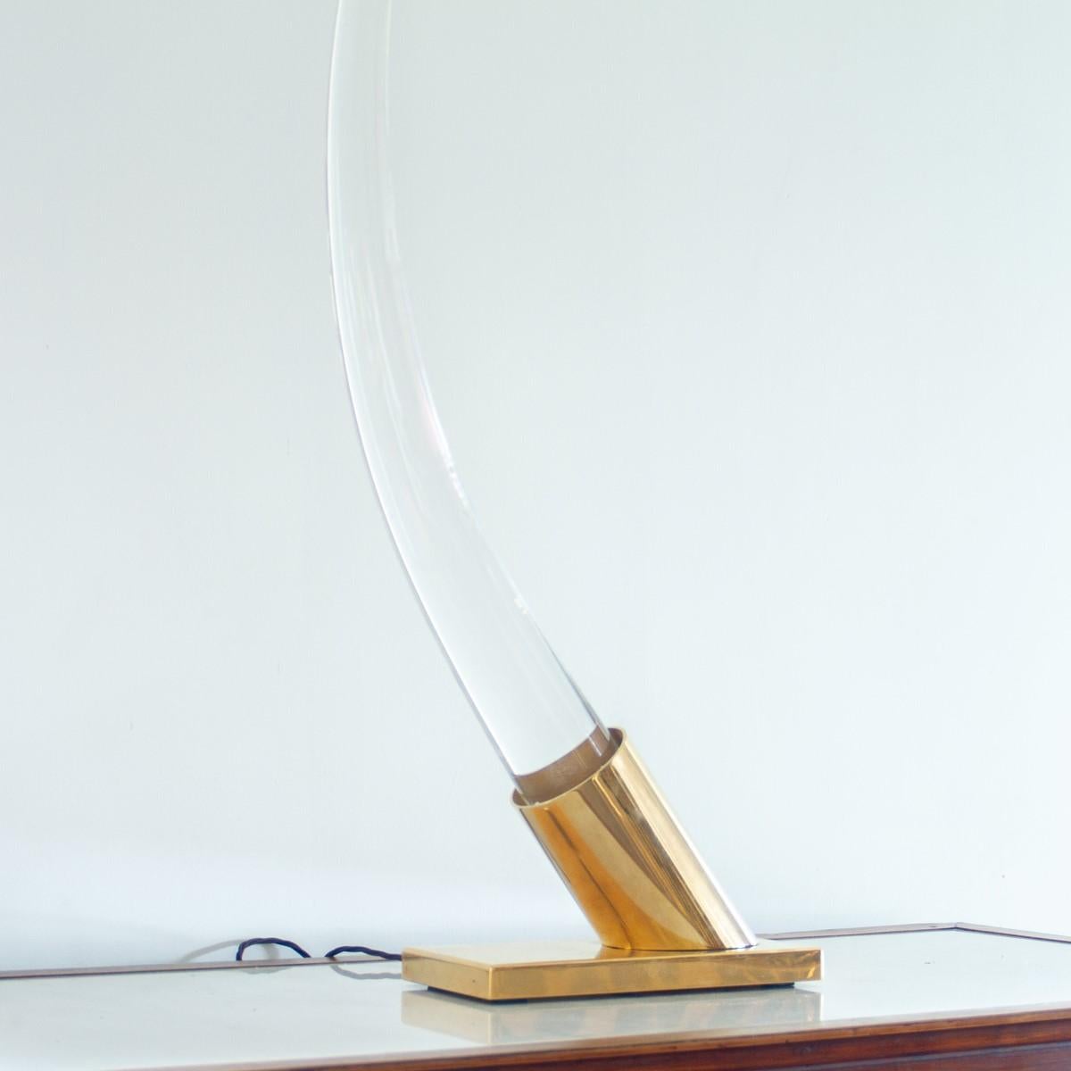 A large lucite sculptural tusk set in a yellow brass base by Oggetti. Oggetti were founded in 1975 and their goal was to show the USA, Italian design which it achieved by working with small ateliers.1980s. The Oggetti label is to the underside of