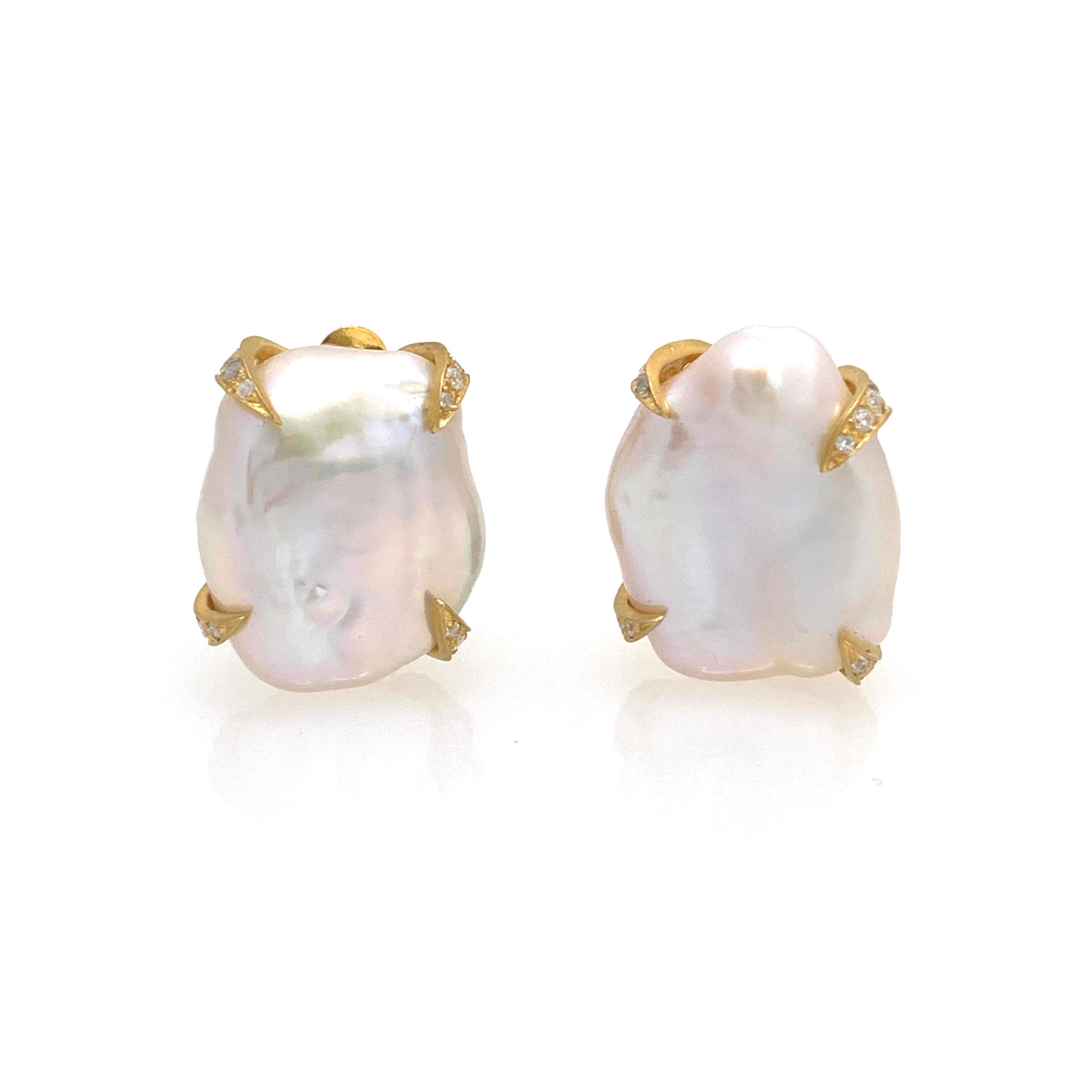 Beautiful pair of large lustrous white flat baroque pearl earrings. The pair measures 18mm width and 22mm height, adorned with round simulated diamonds, all handset in 18k yellow gold vermeil over sterling silver. Large and comfortable clip back