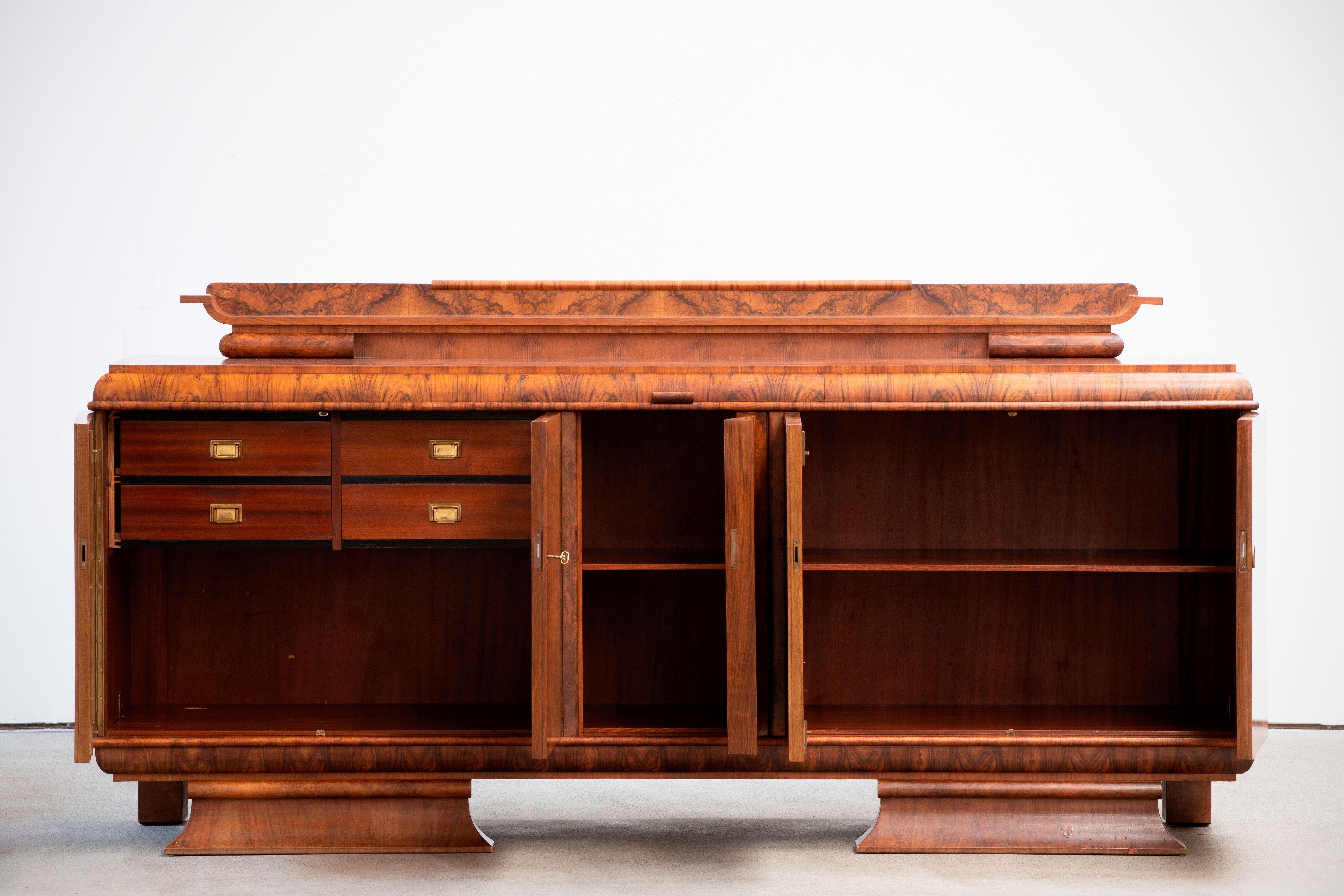 French Art Deco classic burr walnut sideboard, buffet, circa 1930s.
This luxurious piece was originally made in Strasbourg (France) in the 1930s.
The sideboard features four inside drawers and two shelves.
The curved lines of this sideboard and