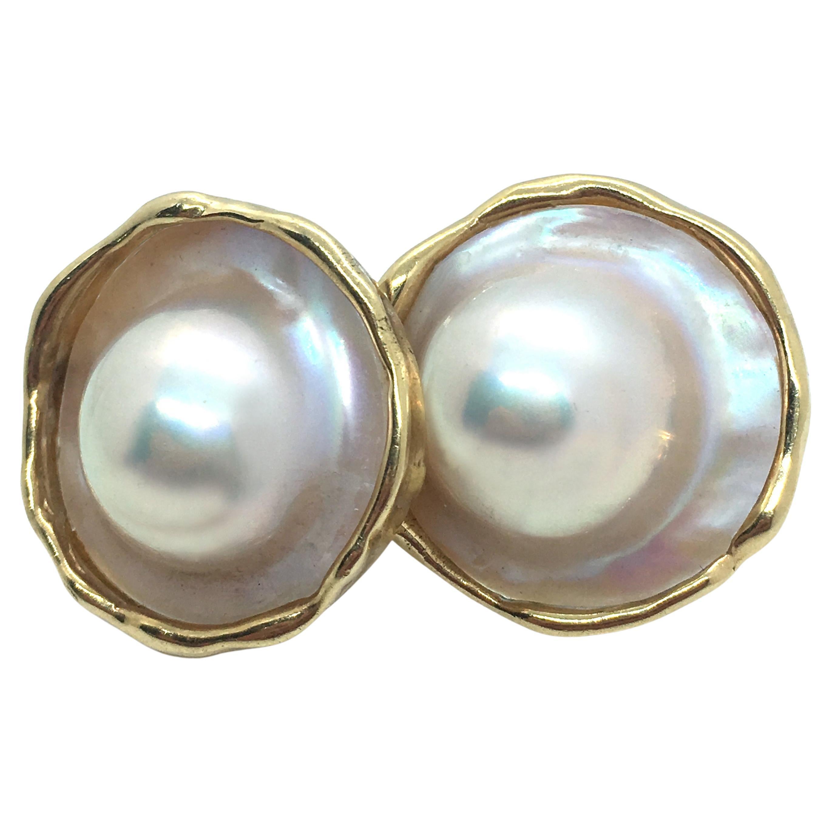 Two gorgeous mabe pearls -- white with pink overtones -- are set in graceful 14 karat yellow gold frames hand-crafted by Eytan Brandes.

The blisters measure approximately 16.5mm while the earrings are just under 1 inch wide.

The post closures stay