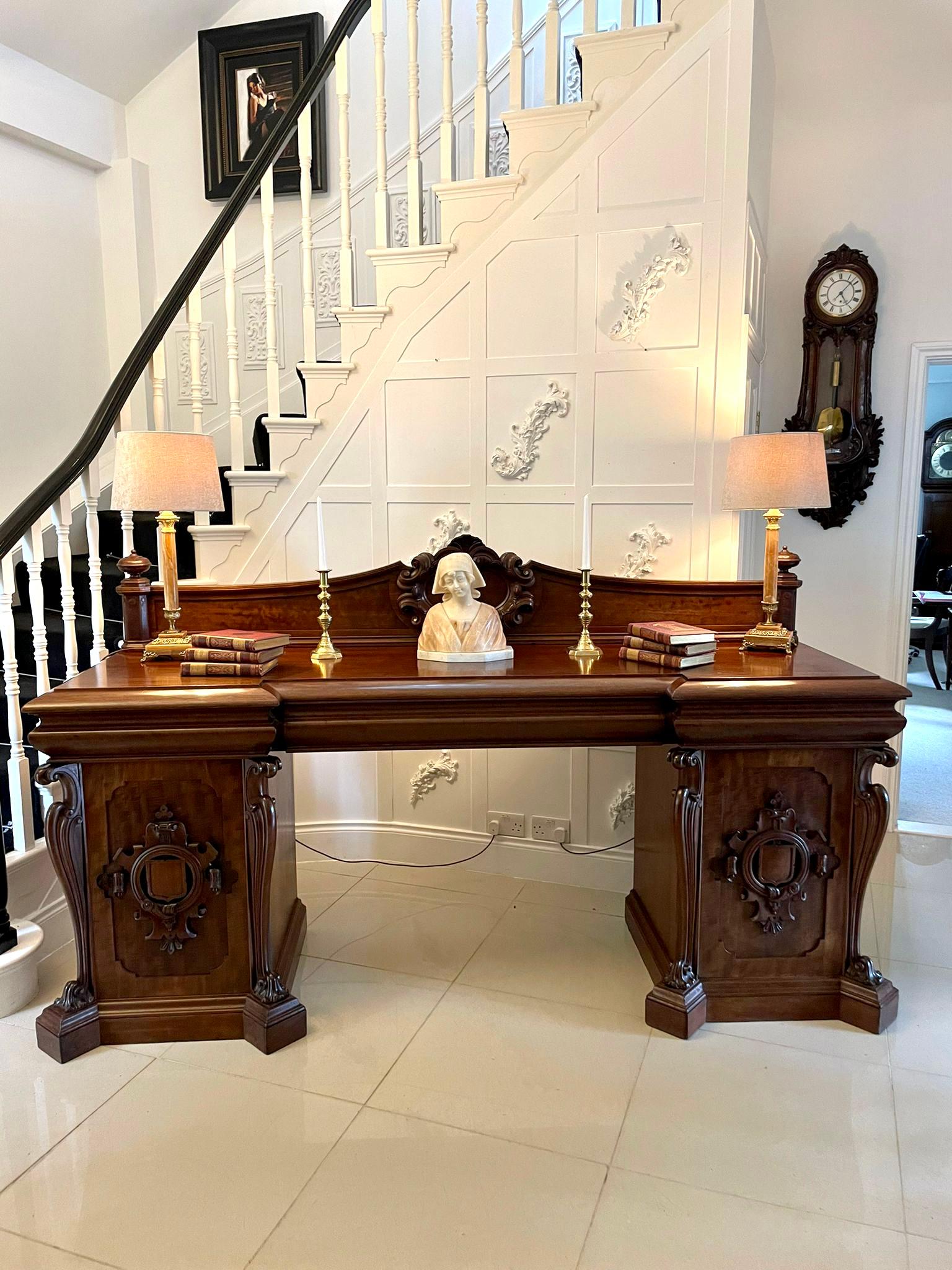 Large magnificent antique William IV carved mahogany sideboard having a beautiful shaped and moulded back with delightful applied carvings to the centre. It has a fantastic flame mahogany inverted breakfront top with three drawers to the frieze. It