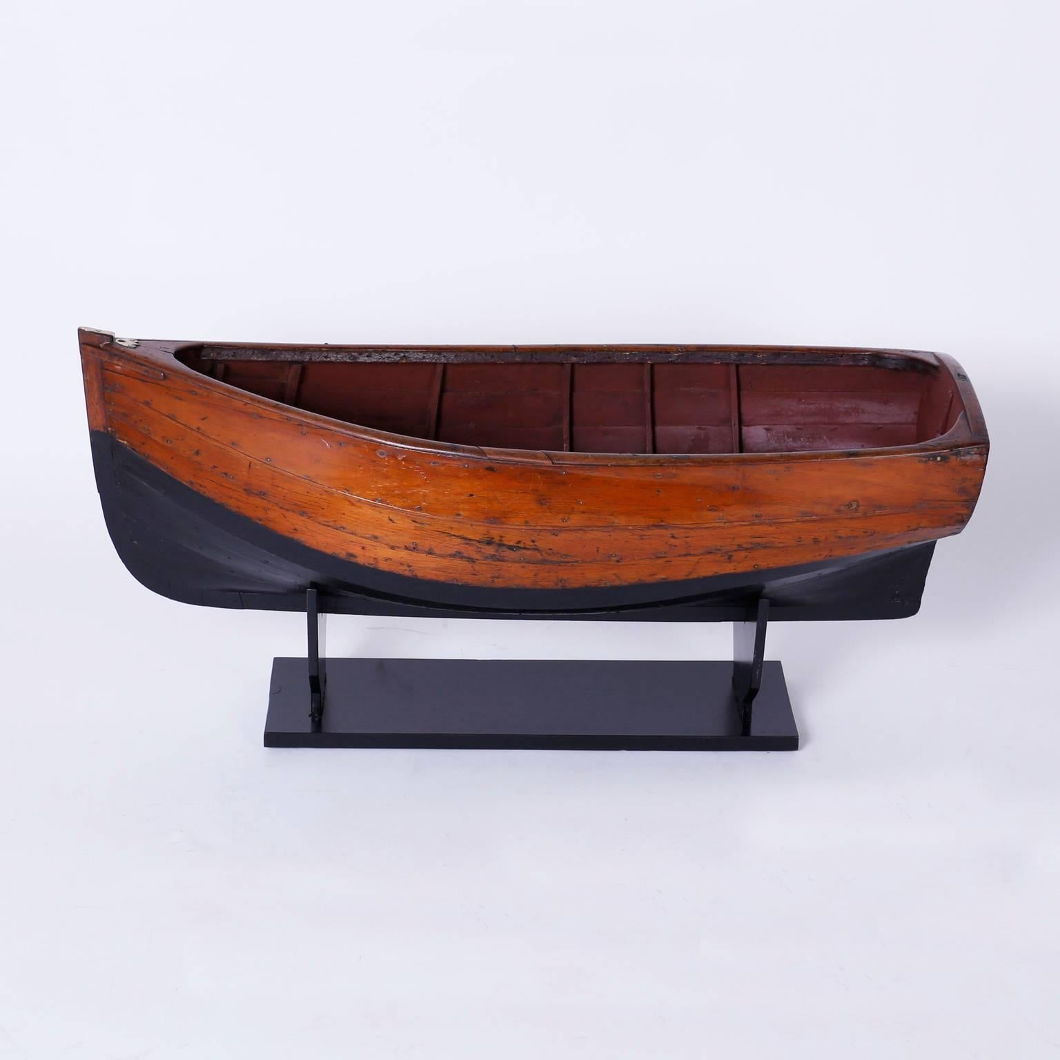 Inspired model of a boat or skiff expertly crafted in mahogany, probably by a boat builder, having a graceful form and has acquired a well earned patina only time can give.