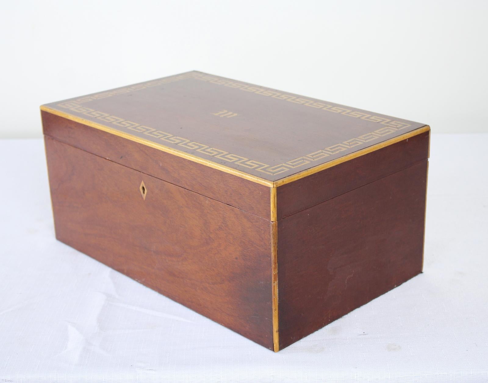 A large pretty jewelry or keepsake box in mellow mahogany with satinwood inlay around the edges, keyhole, and with an elegant W in the middle. The interior is in very good antique condition. Original key.