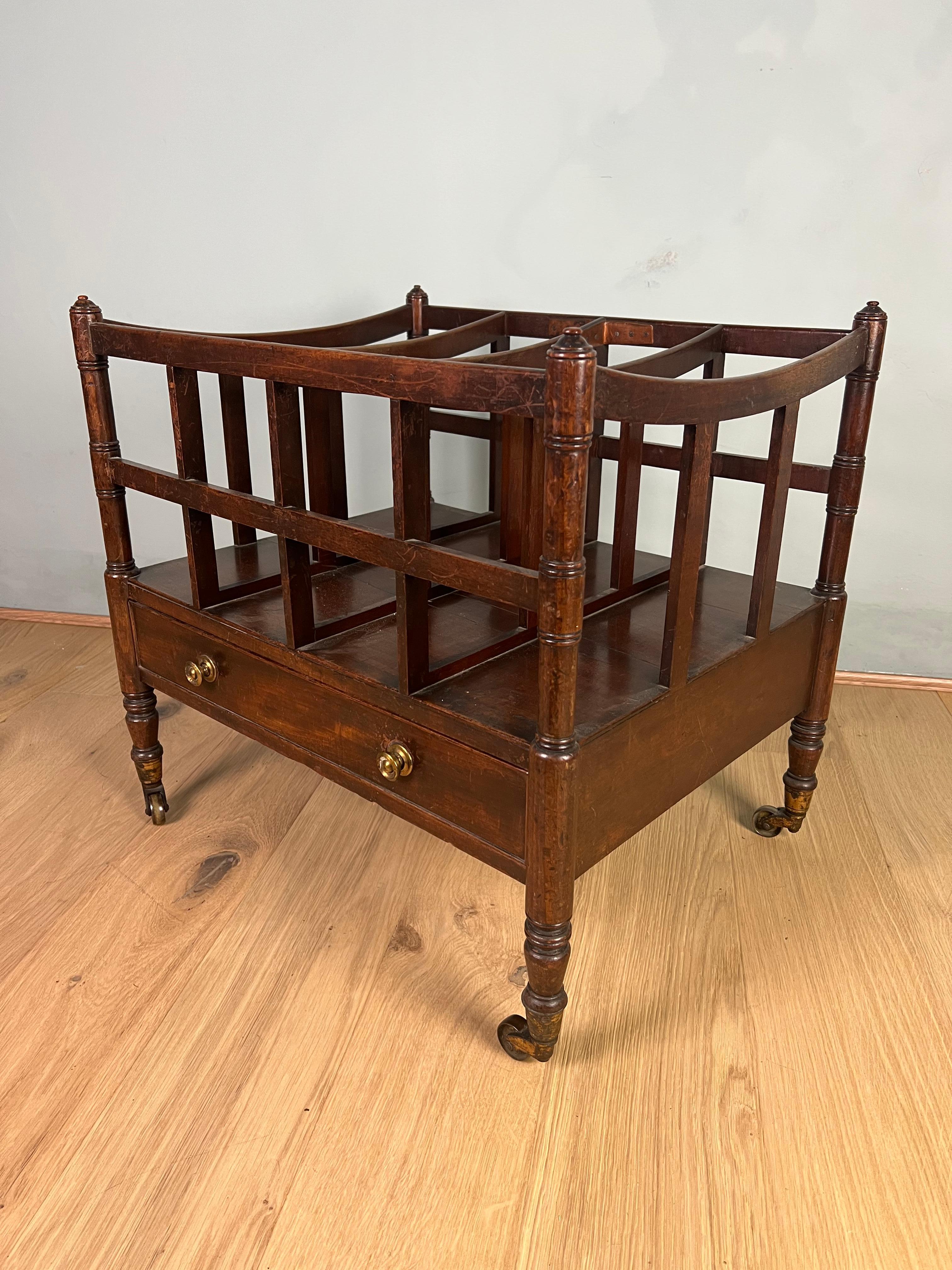 Mahogany Canterbury of good scale, fine turned legs finishing on brass cup casters, making it easy to move around. This large Canterbury has four slatted divisions, so plenty of space for papers and magazines. Below the divisions is a single drawer