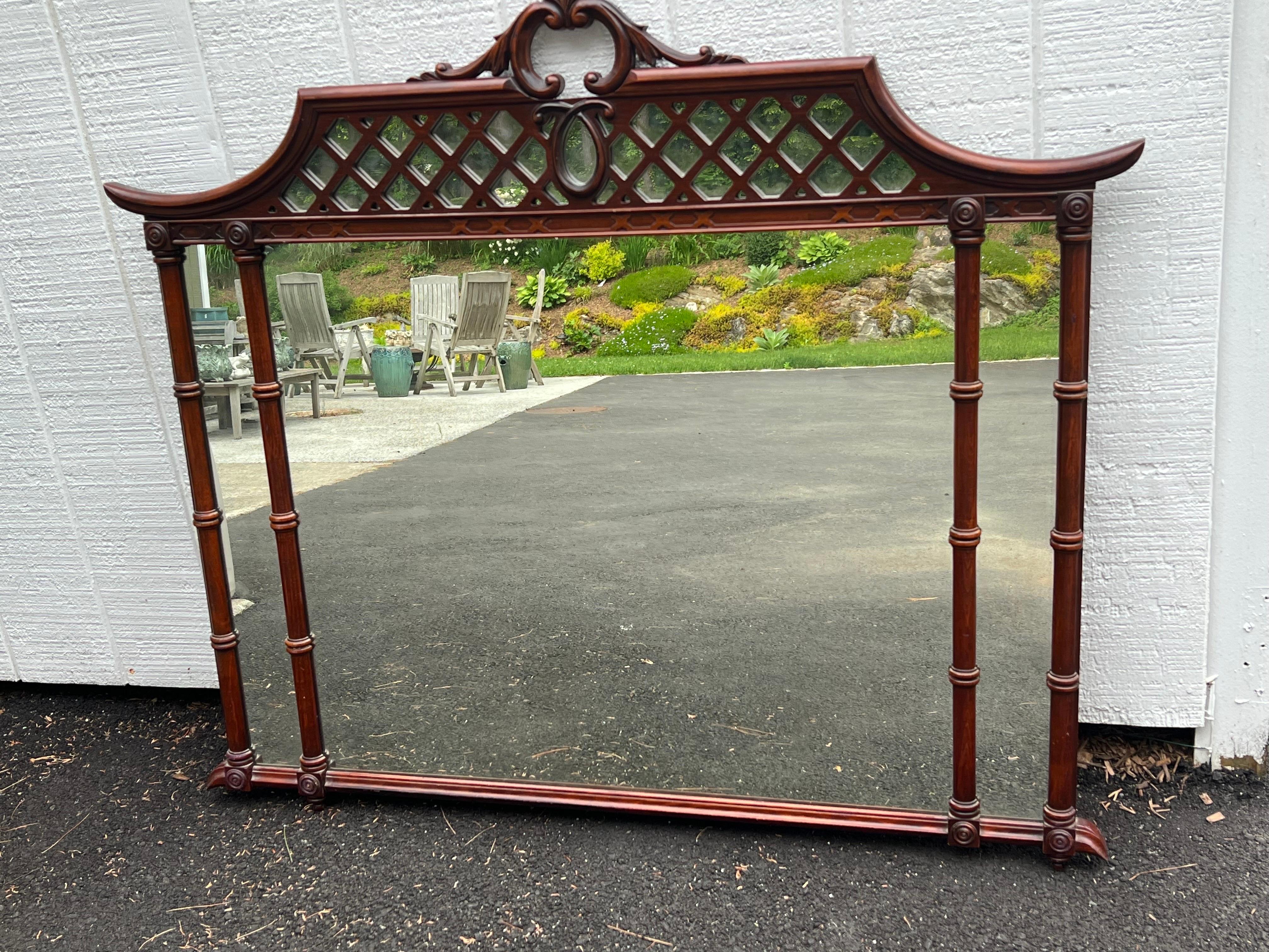 Large Mahogany Chinoiserie Pagoda Mirror. Made of mahogany wood. Perfect for above a dresser or Mantel. Classic faux bamboo detail with a Pagoda style top . 