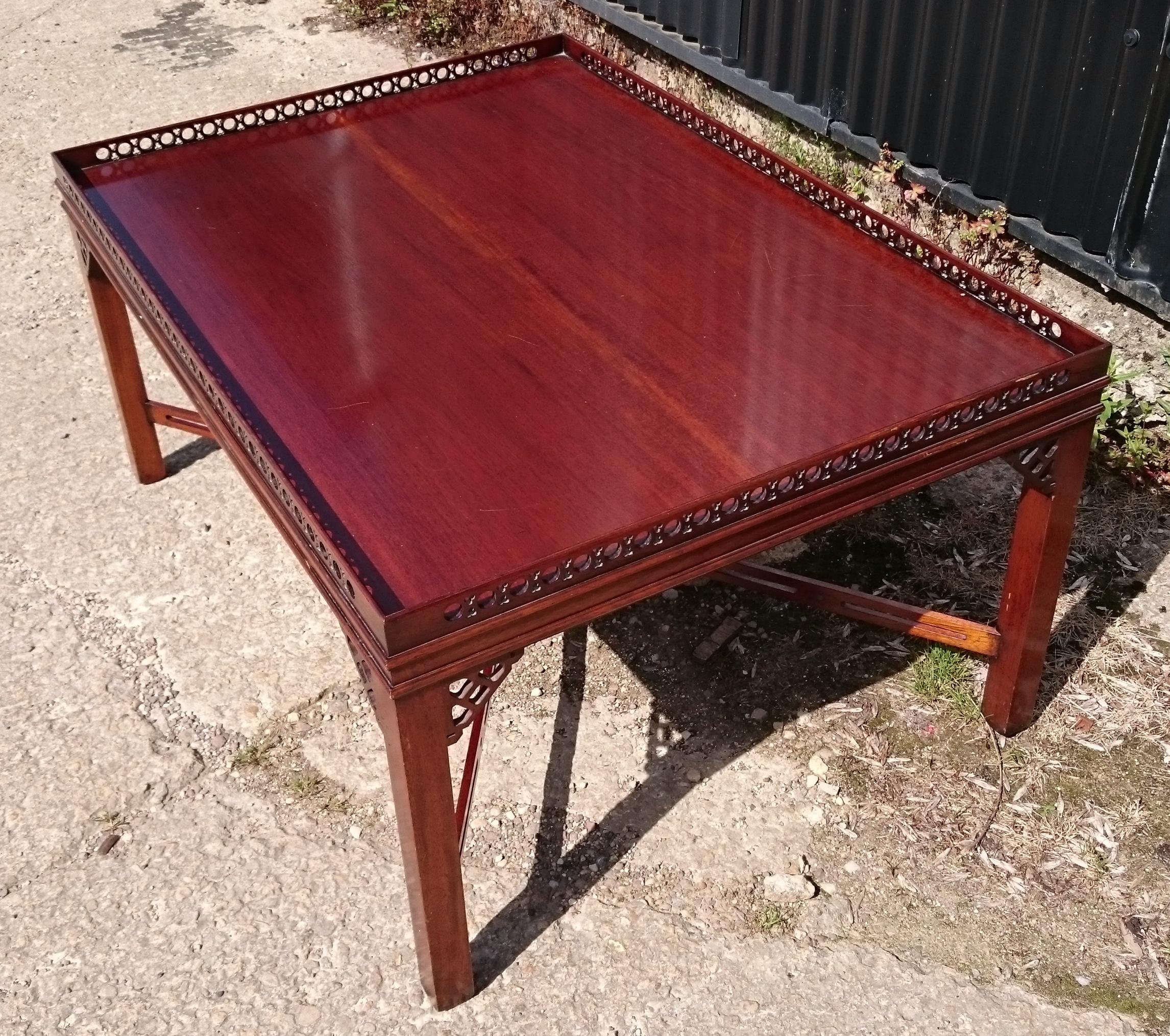 Unusually large mahogany coffee table in the manner of Thomas Chippendale, it has pierced latticework to the gallery and the X-frame cross stretchers. This coffee table is a larger and a lot better made than usual and it must have cost a lot of