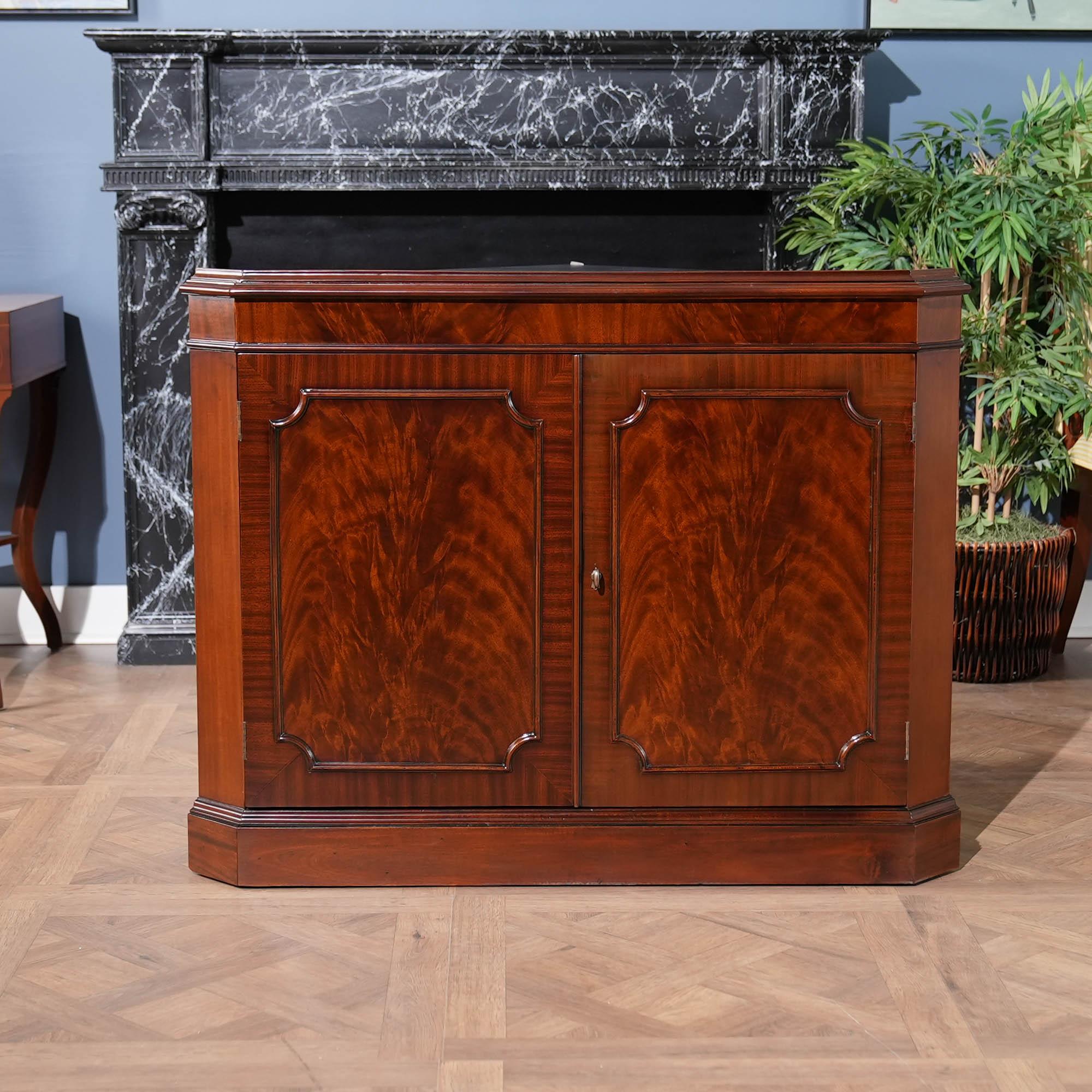 This double door, Large Mahogany Corner Cabinet is manufactured from kiln dried, plantation grown, mahogany, and features figured mahogany veneers on the door fronts. The attention to detail and expert craftsmanship is apparent in the hand carved