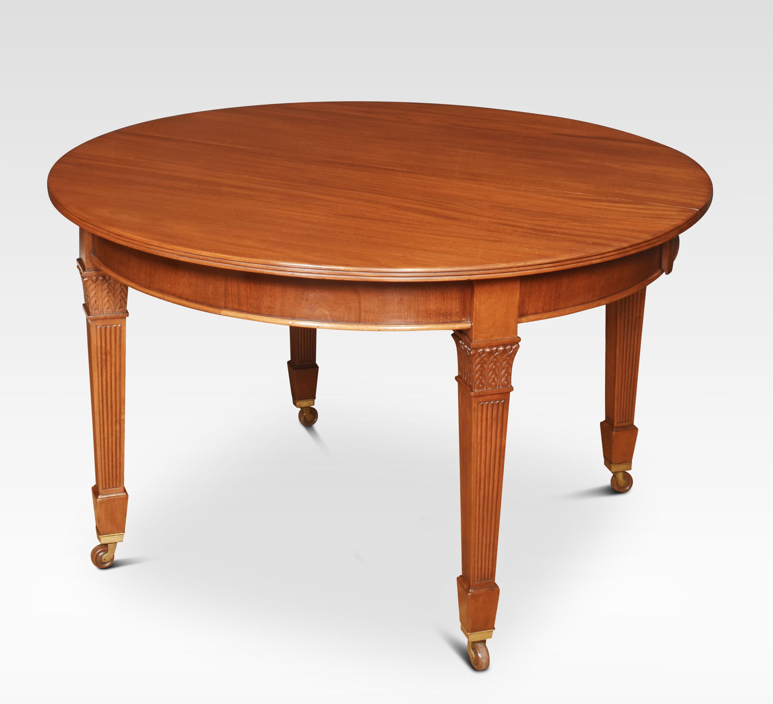 Mahogany dining table, the rectangular top with oval ends having moulded edge to the telescopic action, with solid mahogany runners opening to incorporate three leaves. All raised up on reeded tapering legs with brass terminals and ceramic casters