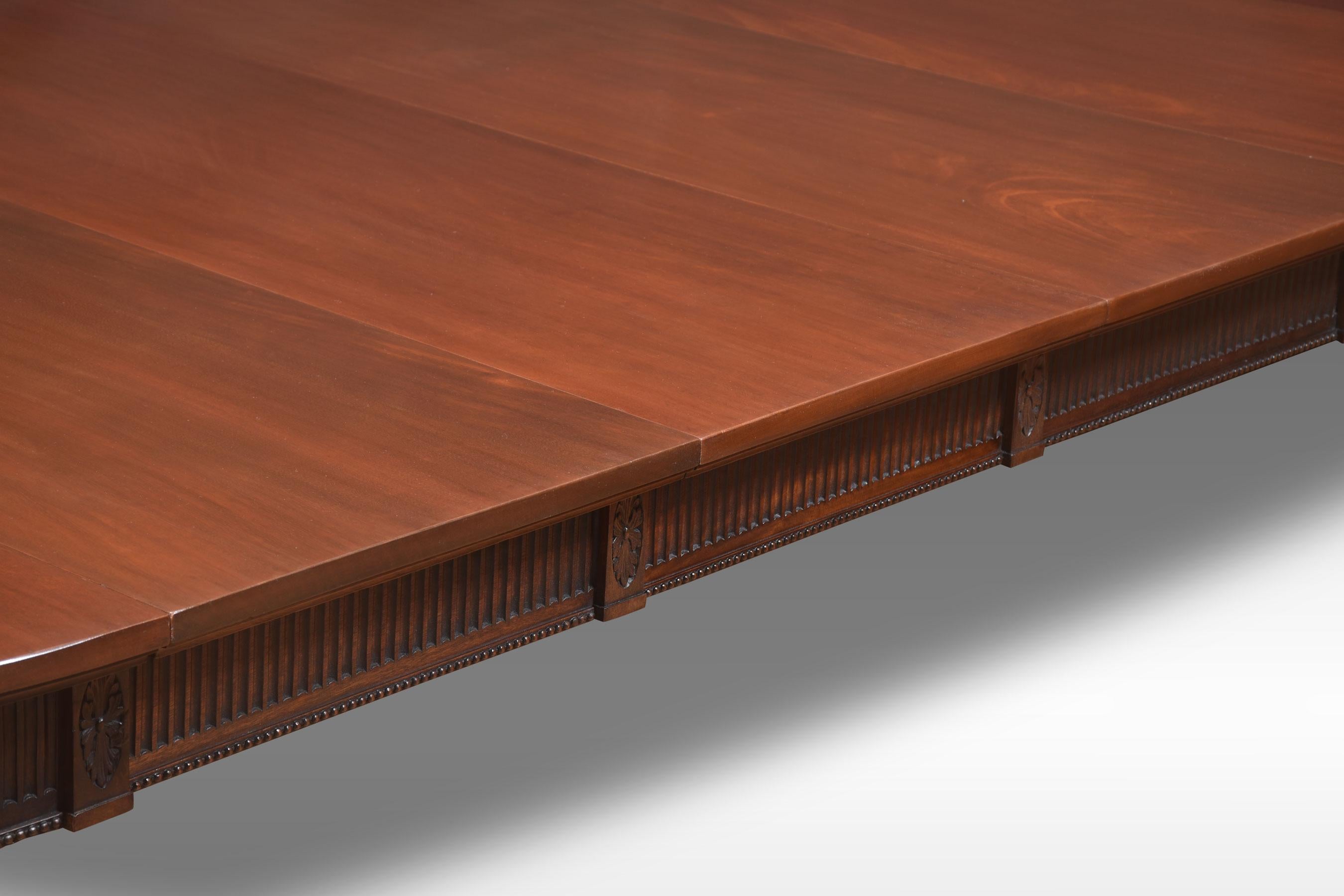 Mahogany dining table, the rectangular top with oval ends having moulded edge to the telescopic action, with solid runners opening to incorporate four leaves. All raised up on reeded tapering legs terminating in ceramic castors. will seat 12 to 14