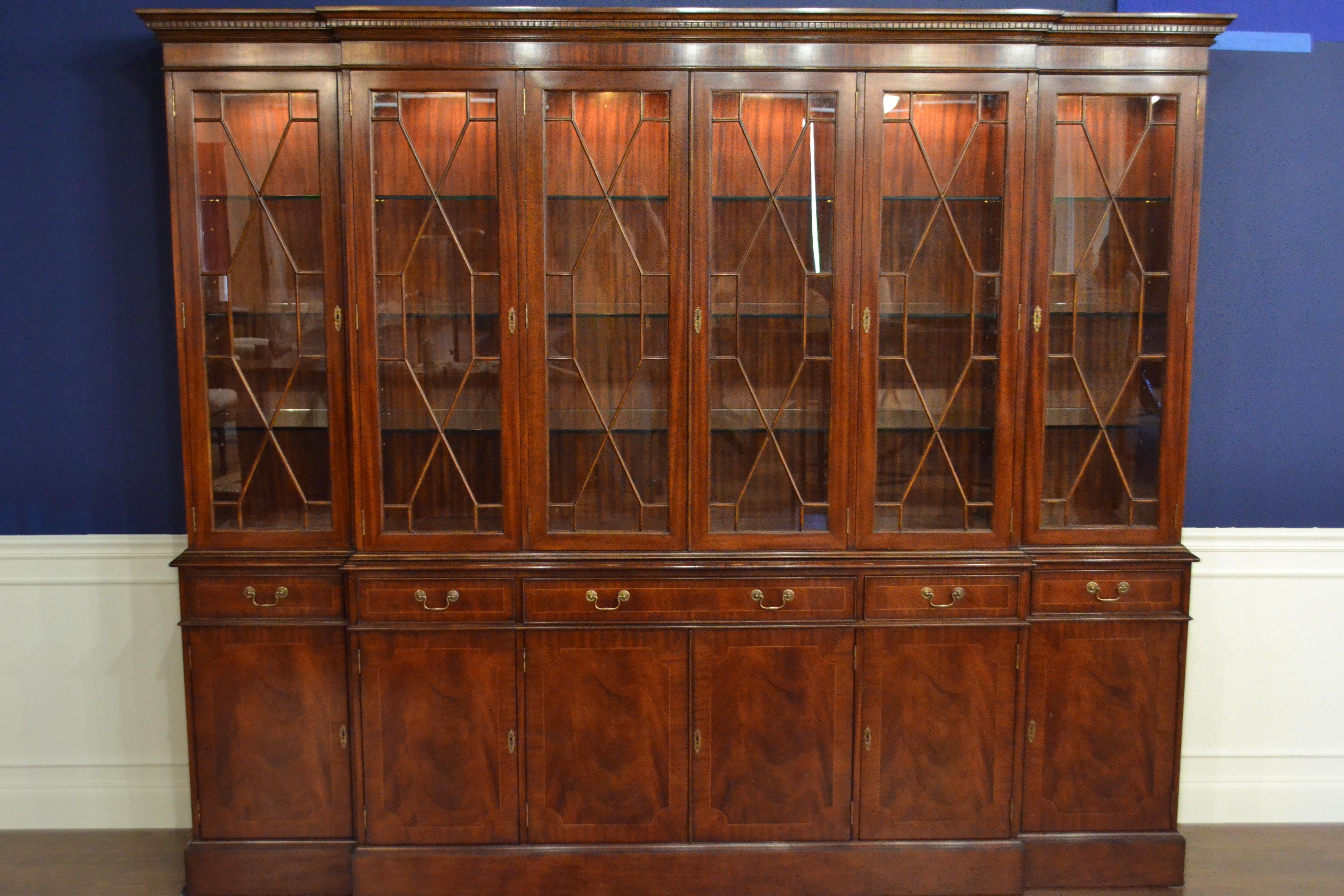 This is the ultimate large traditional mahogany breakfront bookcase or china cabinet with six doors by Leighton Hall. It features six bottom doors and drawers with swirly crotch mahogany fields and straight grain mahogany borders. The top doors