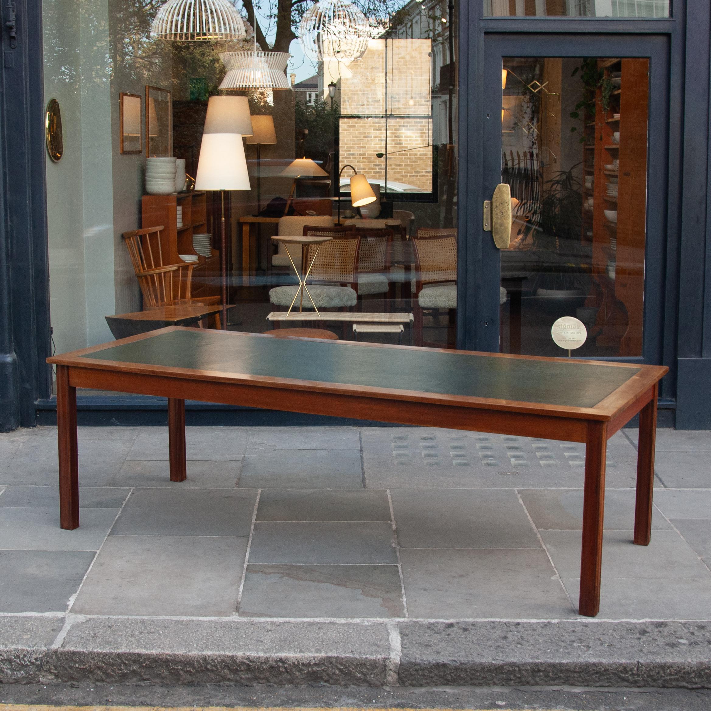 A 1940s Danish mahogany library table with leather insert would be most appropriate used today as a large desk or dining table. This substantial neoclassical table is an example of Danish cabinetmakers adopting the British aesthetic vernacular. The