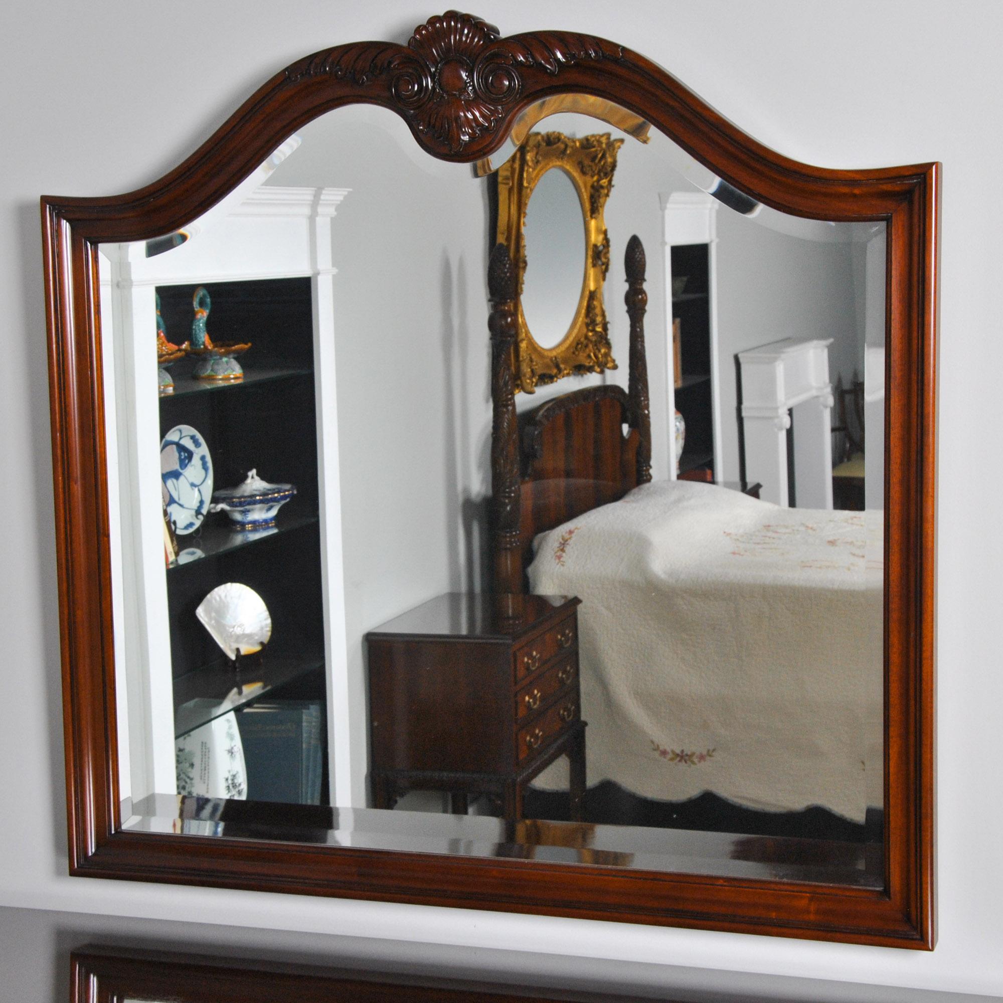 The Large Mahogany Mirror features a solid mahogany frame with a crest of hand carving. This helps discern the mirror from its' mass produced counter parts found elsewhere. Thick, great quality bevelled glass is used inside the frame and the Large