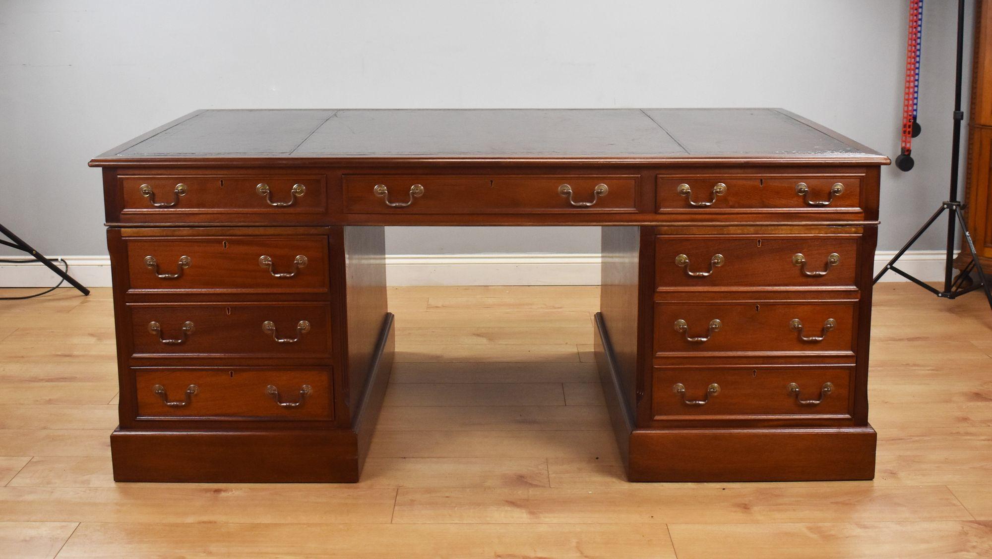 For sale is a good quality large mahogany partners desk, having an inset leather writing surface, decorated with black tooling, above three drawers in the front, with three further drawers on the opposing side. The top fits on to two pedestals, each