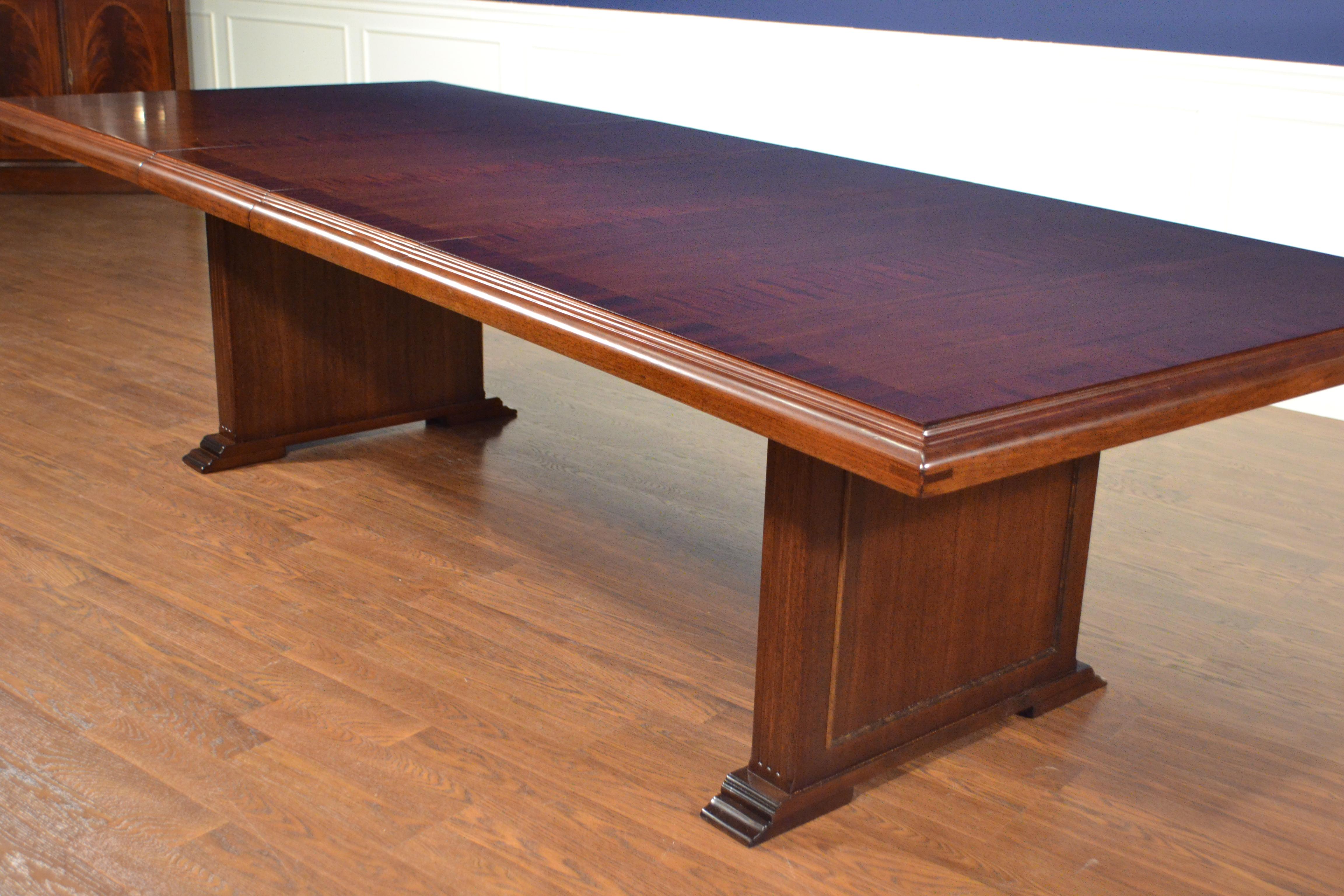 This is a made-to-order mahogany conference table made in the Leighton Hall shop. It features a field of cathedral mahogany with a straight grain mahogany border and a solid mahogany edge. It has two 