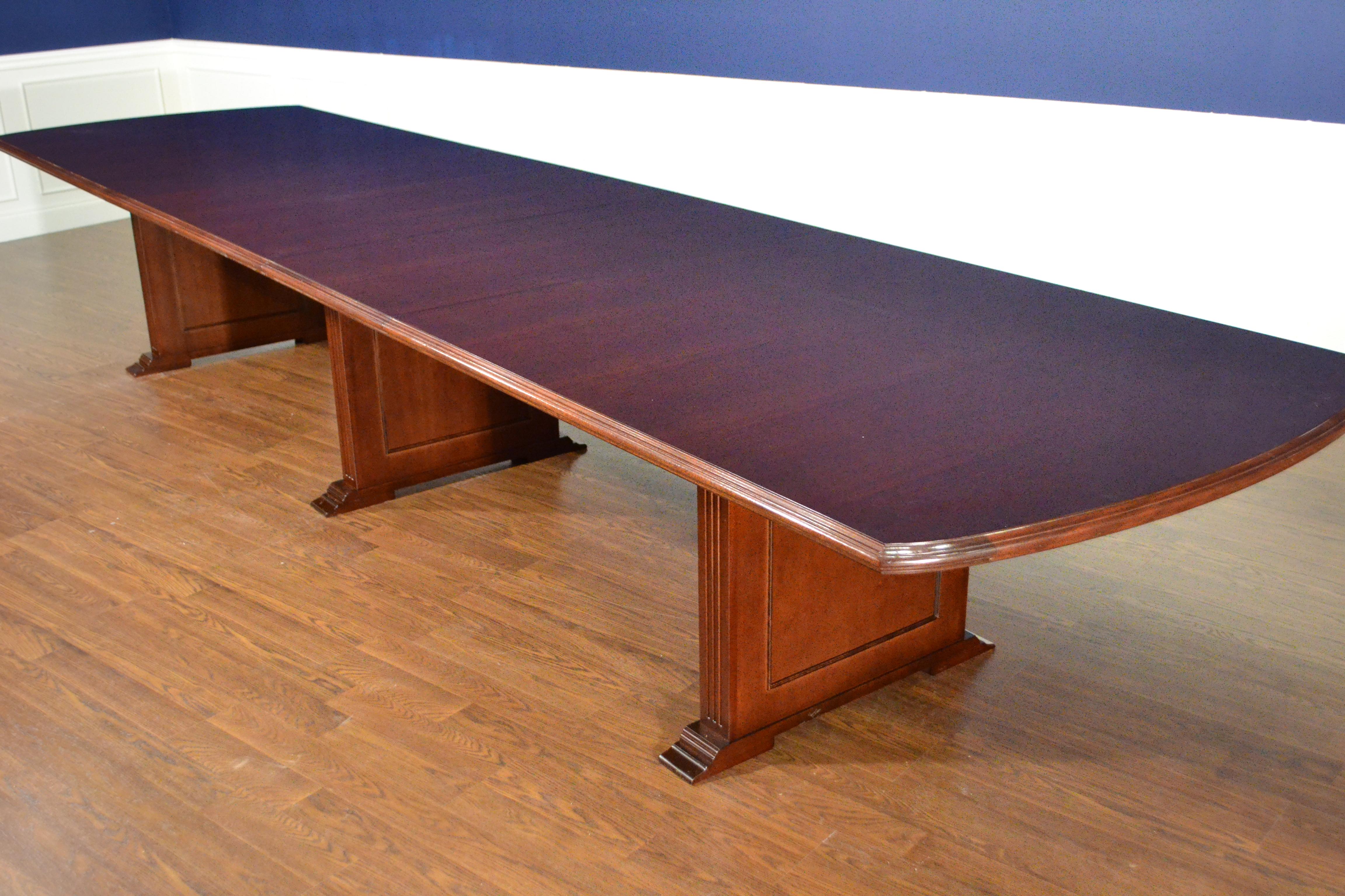 This is a made-to-order mahogany conference table made in the Leighton Hall shop. It features a field of cathedral mahogany with an Ogee-shaped solid mahogany edge. It has three 