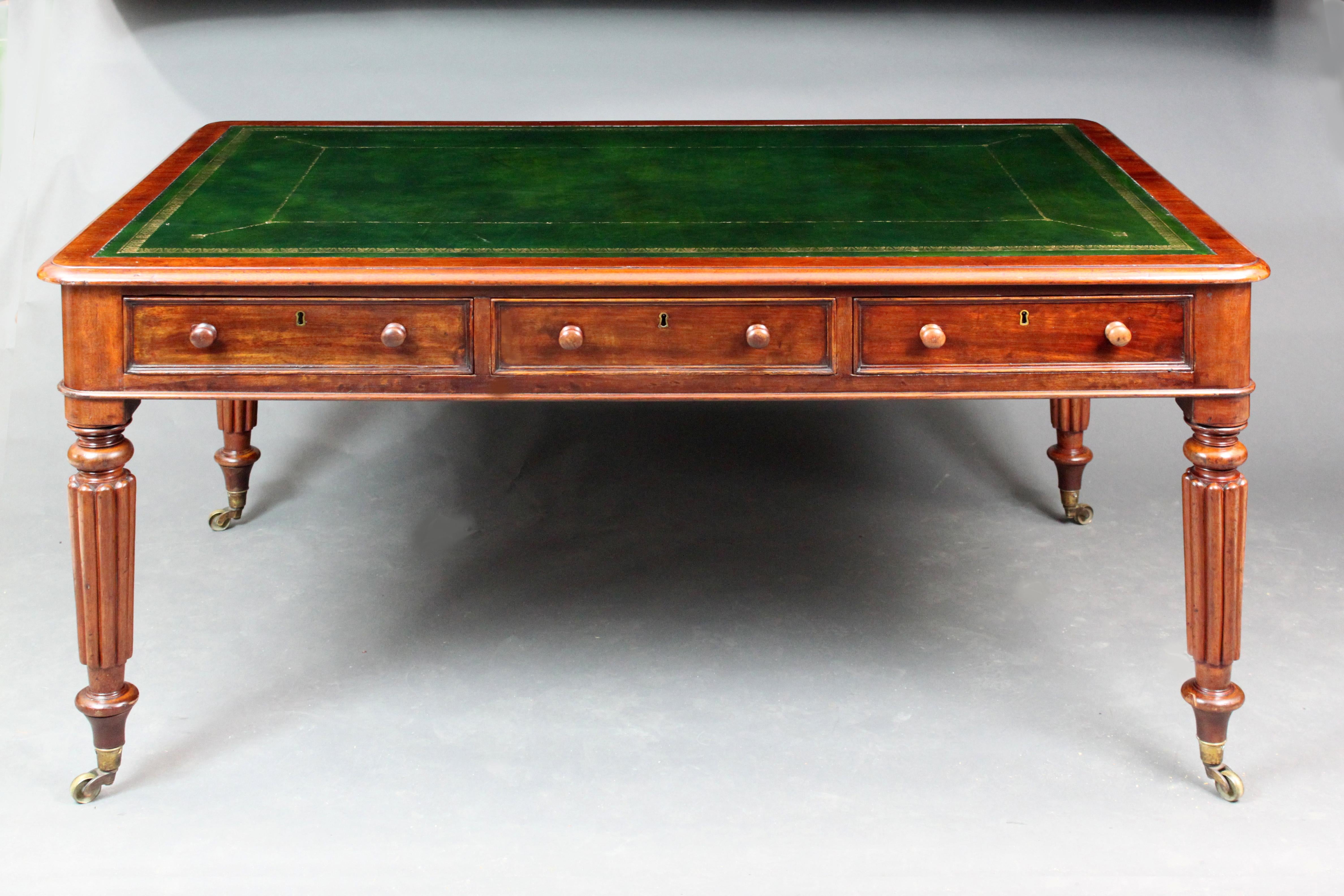 William IV partners writing table on turned and reeded legs, six oak-lined drawers and a recently replaced dark green hide.