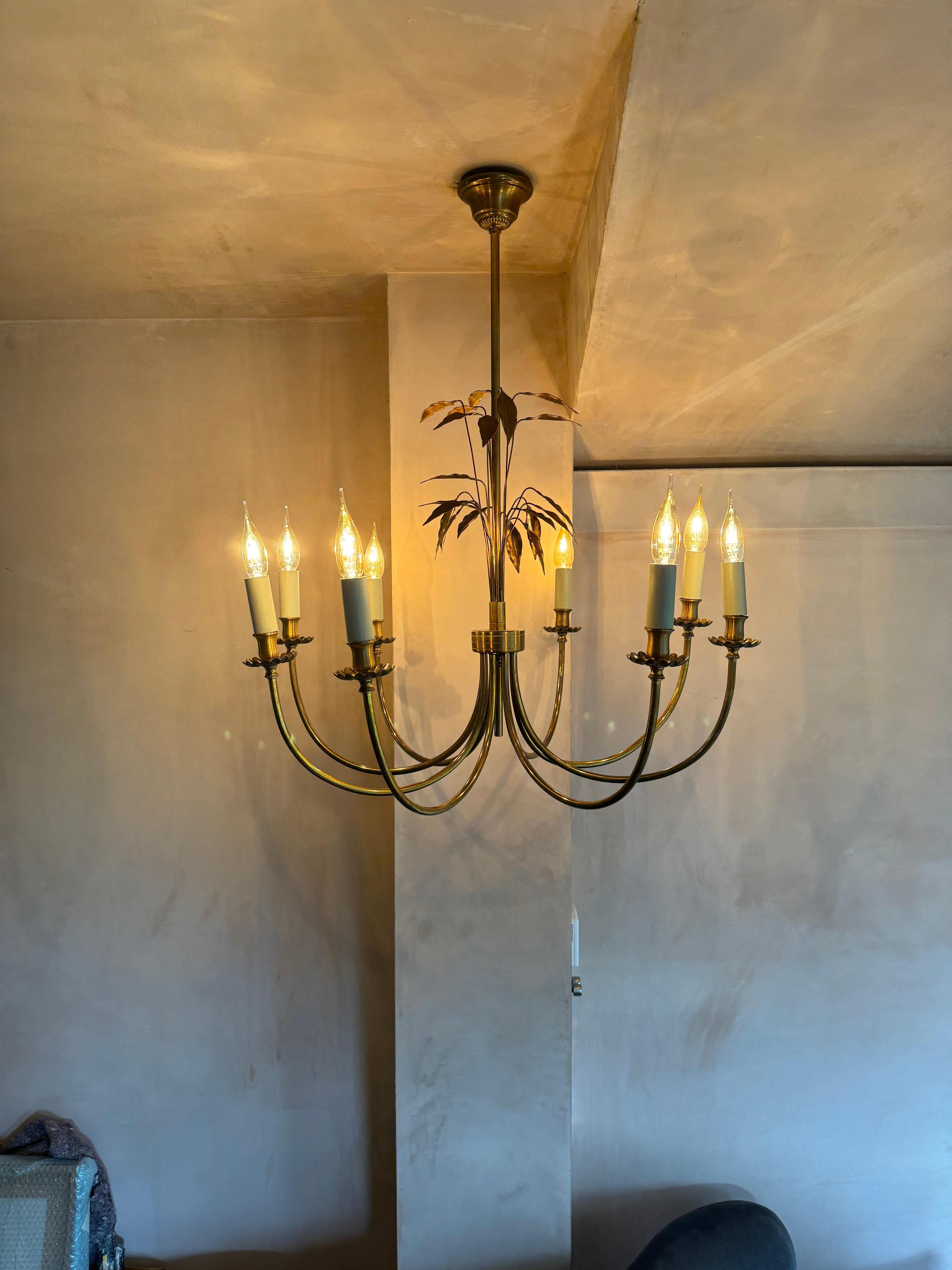 A beautiful gilt metal large 8 armed chandelier with leaf detail in the style of Maison Charles. Rewired. Would suit both a classical or modern interior. 
 