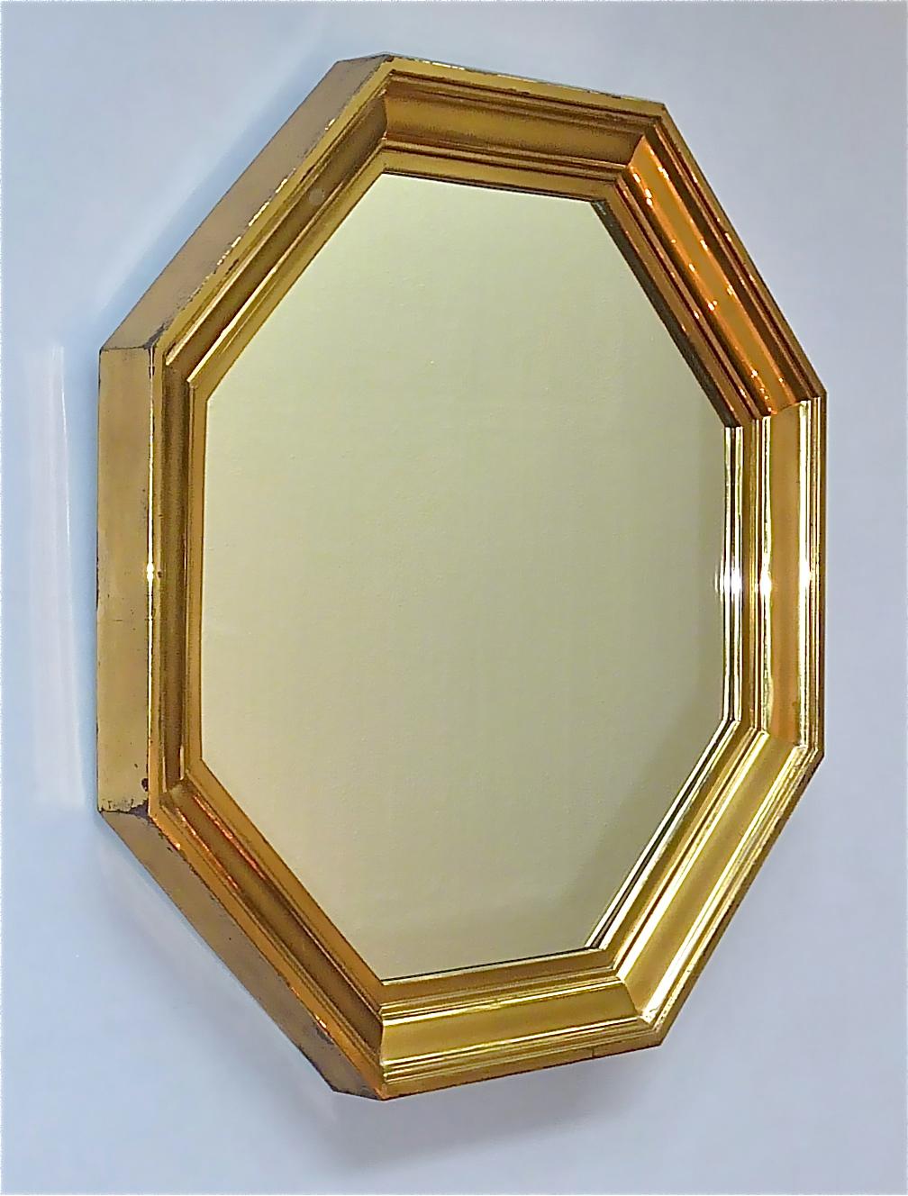 Fantastic large octagonal Maison Jansen mirror, France, around 1970s. Probably designed by Sandro Petti or Guy Lefevre the beautiful mirror has an octagonal shape made of a stepped patinated brass frame with mirror glass on a wood base. The high