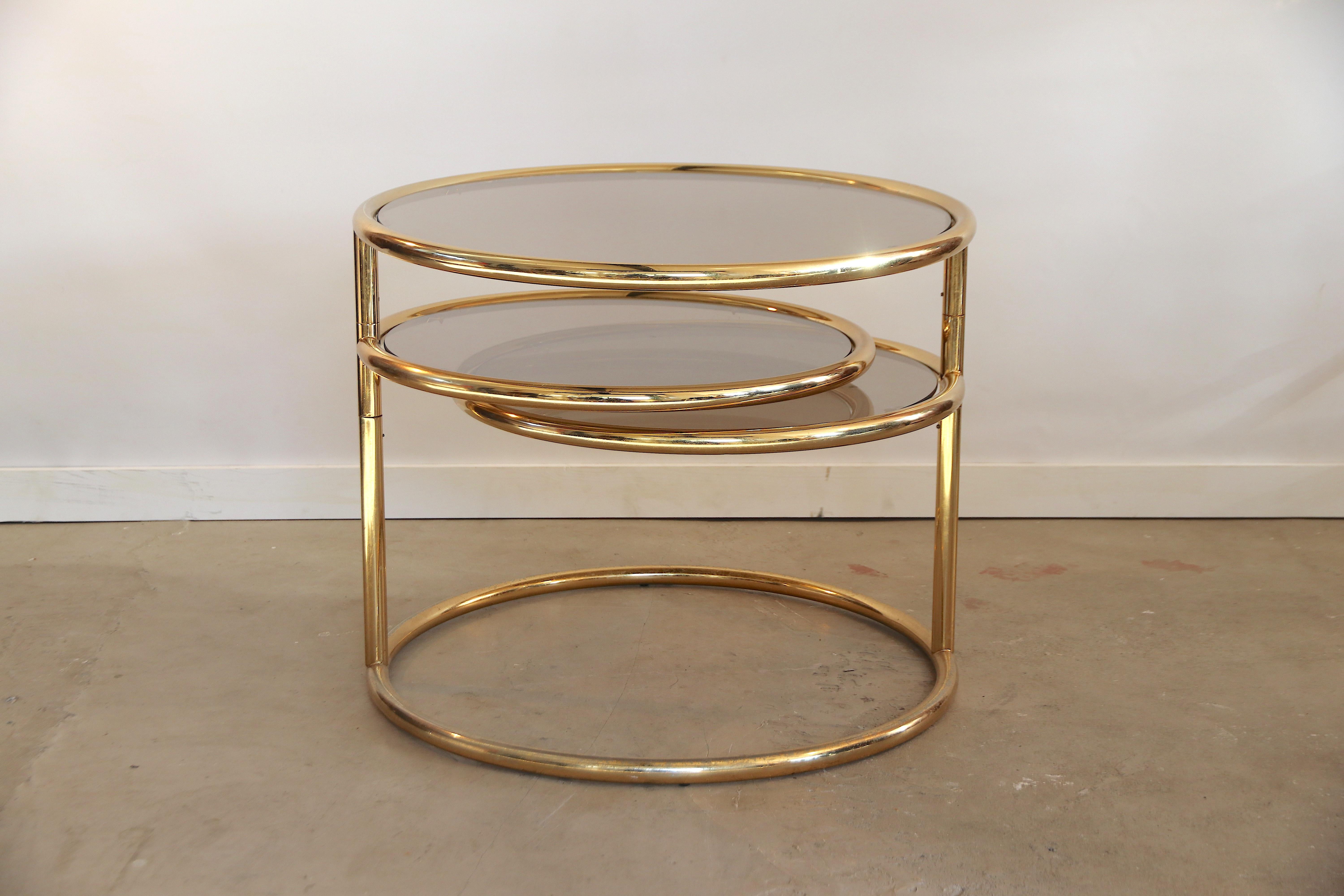 Very rare to find shiny brass 3-tier coffee or side table with completely unscratched smoked bronze-tinted glass. The upper glass top level is in a fixed position, the 2 lower level tops can swivel 360 degrees around, so while sitting on your sofa