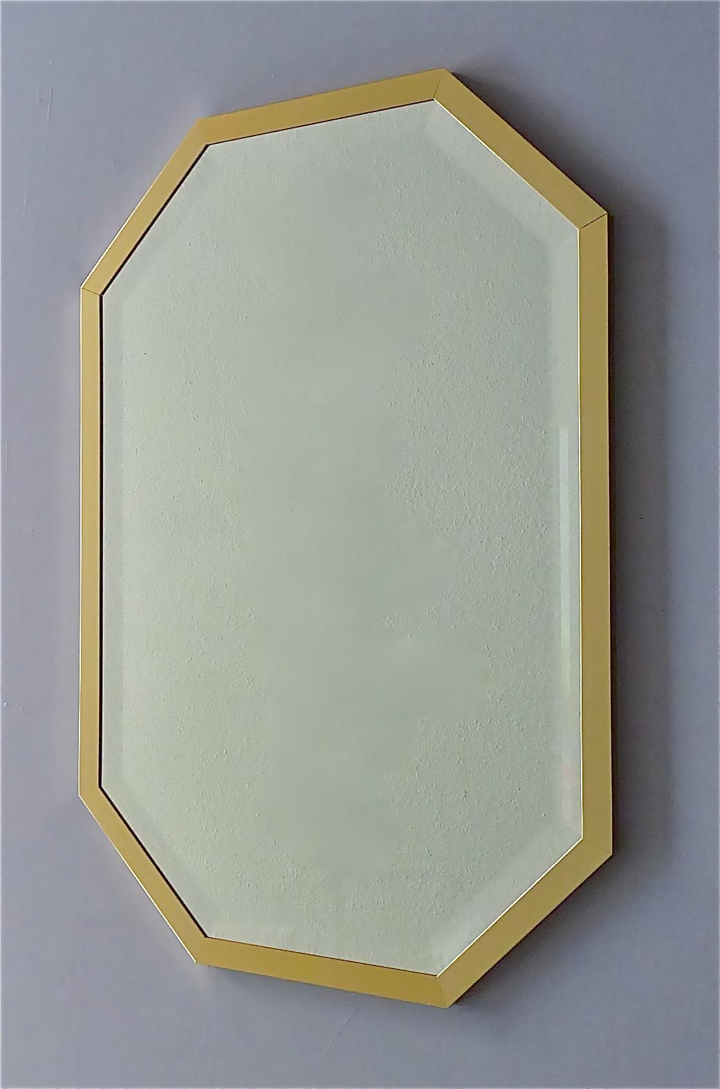 Magnifique grand miroir octogonal de style Maison Jansen, Gabriella Crespi, Willy Rizzo, fabriqué en Allemagne vers les années 1970. Le miroir de haute qualité a une forme octogonale avec un cadre en laiton doré et un miroir en cristal facetté. Le