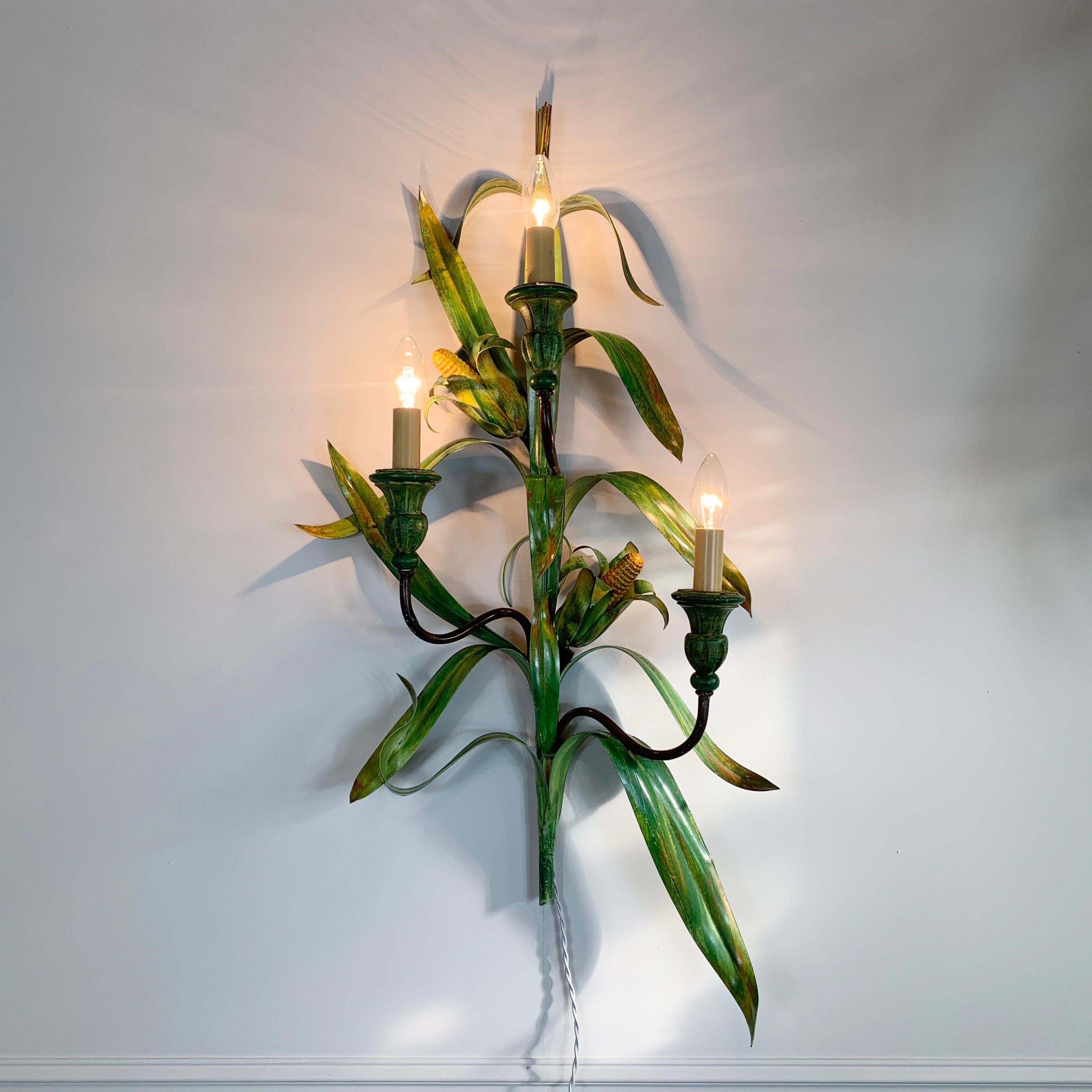 A rare & very large painted tole wall light in the design of maize stem with corn cobs and leaves, tipped with maize seed heads

Measures: 90cm height, 50cm width, 17cm depth

There are 3 lampholders which take e14 bulbs

Original loop hook to