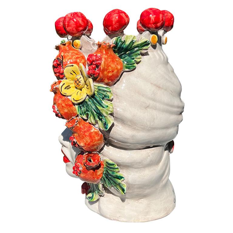 A large colorful polychrome hand-made ceramic Italian Moorish bust vase or planter of a woman with a flower turban crown. Handmade and glazed in brilliant reds, greens, and yellows, this sculpture depicts the head of a lady wearing a glazed red