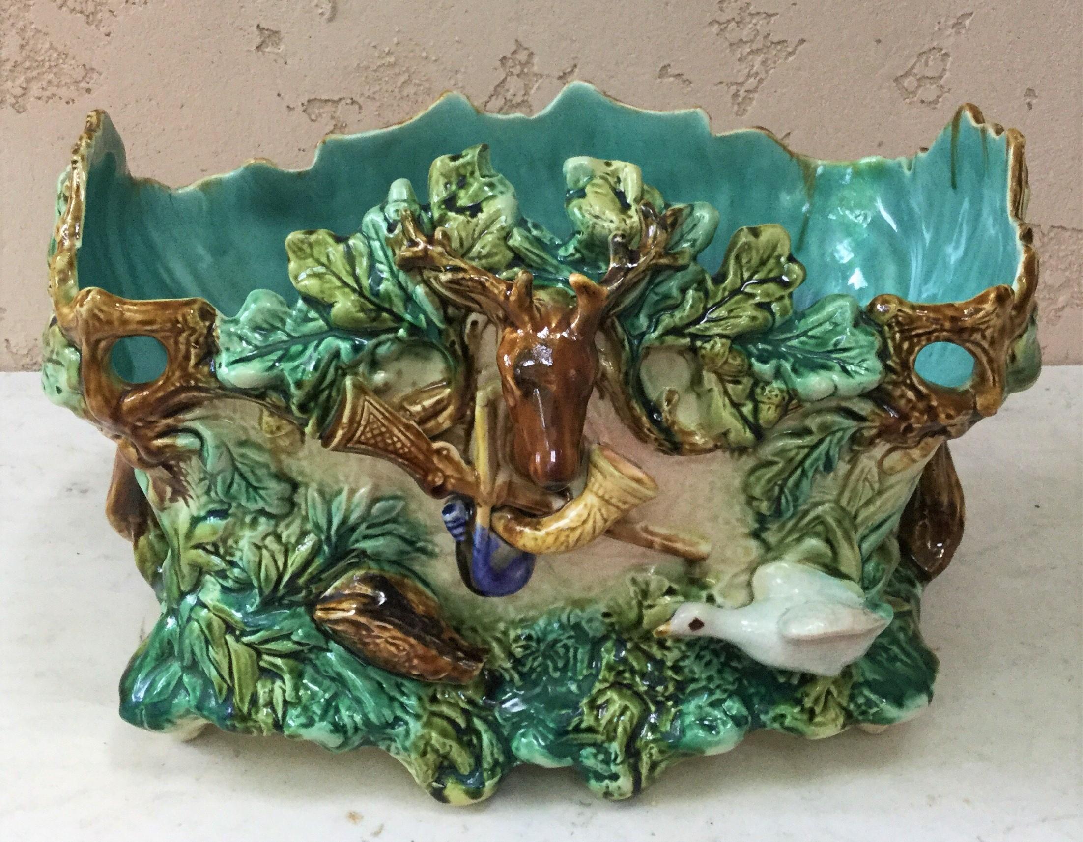 19th century large rectangular Majolica hunt jardinière signed Onnaing.
The planter is decorated with a deer head on the front , oak leaves and acorns , hunting symboles( gamebag, horn and carbine ) on the front also a boar head and a goose.