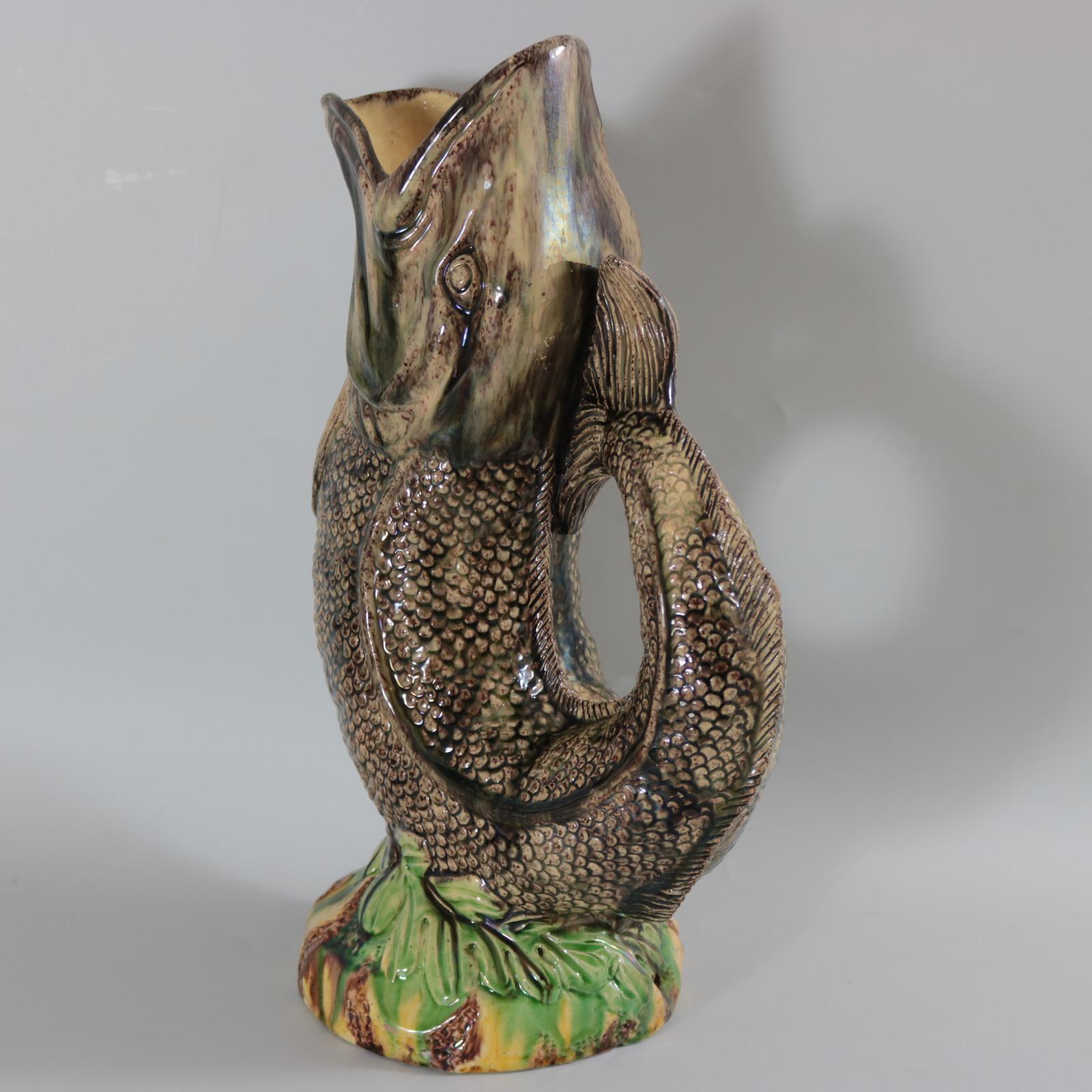 European/Continental Majolica jug/pitcher which features a leaping fish, mouth wide open, on a bed
of leaves. Colouration: grey, green, yellow, are predominant.
