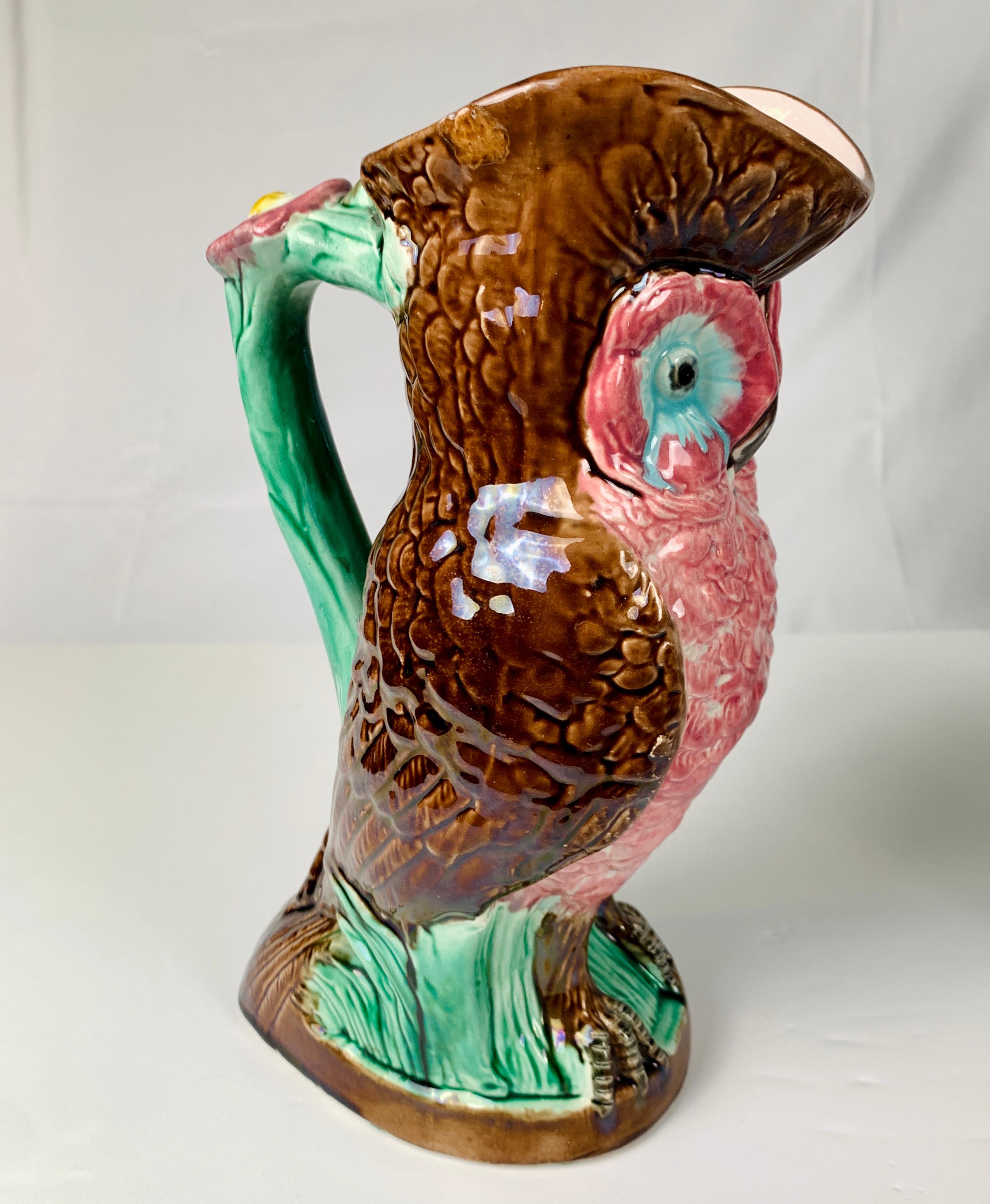 A marvelous Majolica owl made in the Art Nouveau style in England circa 1890. 
The figure is painted in bright enamels with stunning pink breast feathers, turquoise eyes, and deep brown feathers on the sides and back. 
The owl stands on a twisting