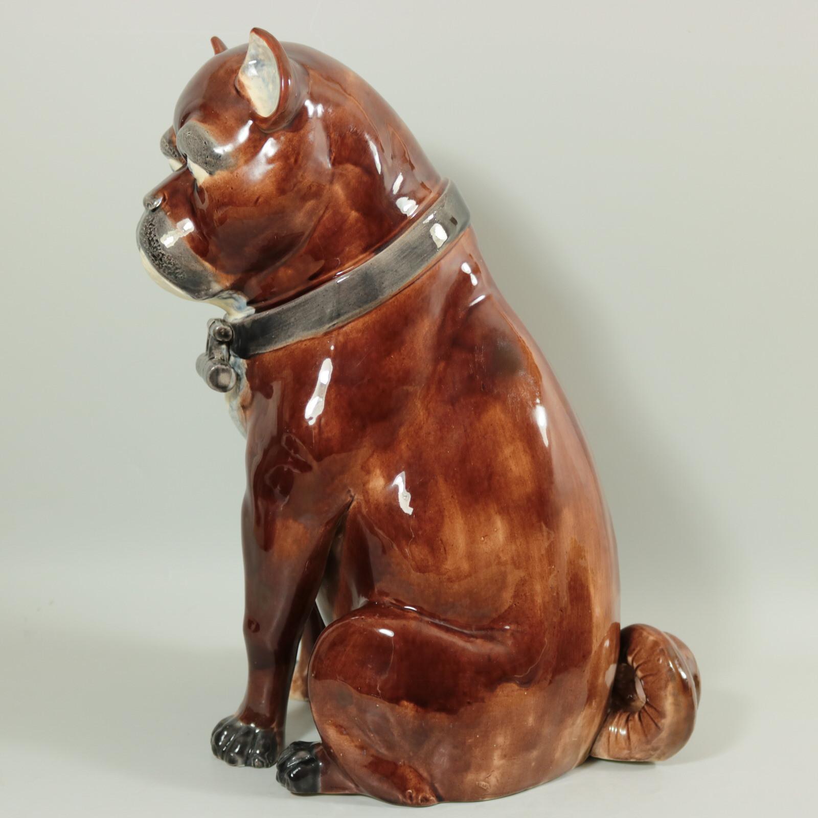 Unidentified English or European Majolica figure which features a pug, wearing a collar with a locket. Colouration: brown, white, grey, are predominant. Bears a pattern number, '..'.