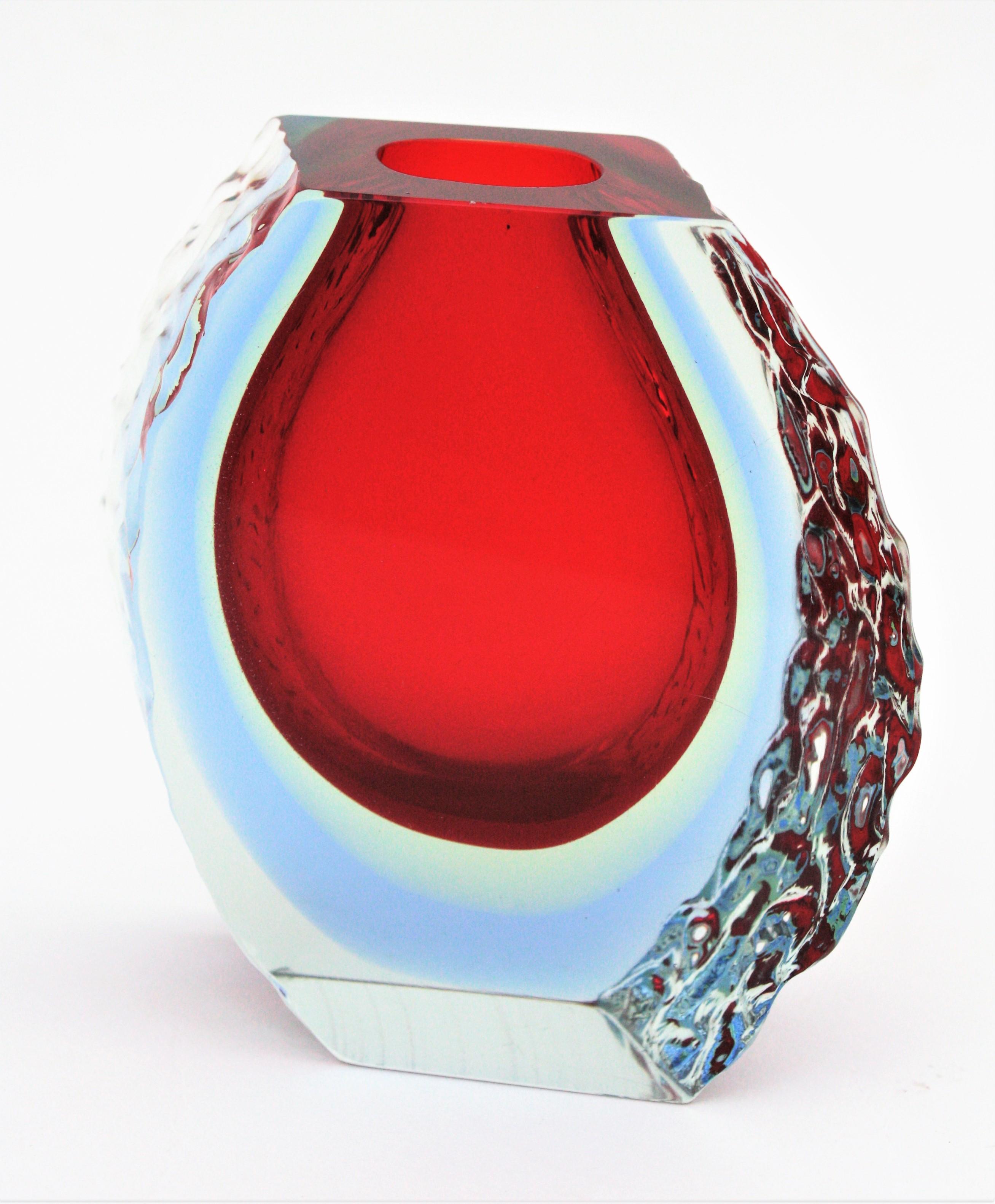 Eine farbenfrohe dreifache Sommerso-Vase aus der Jahrhundertmitte mit strukturiertem Eisglas an den Seiten. Alessandro Mandruzzato zugeschrieben, Italien, 1960er Jahre.
Diese leuchtend rote Vase kombiniert die Sommerso-Technik (rotes, hellgelbes
