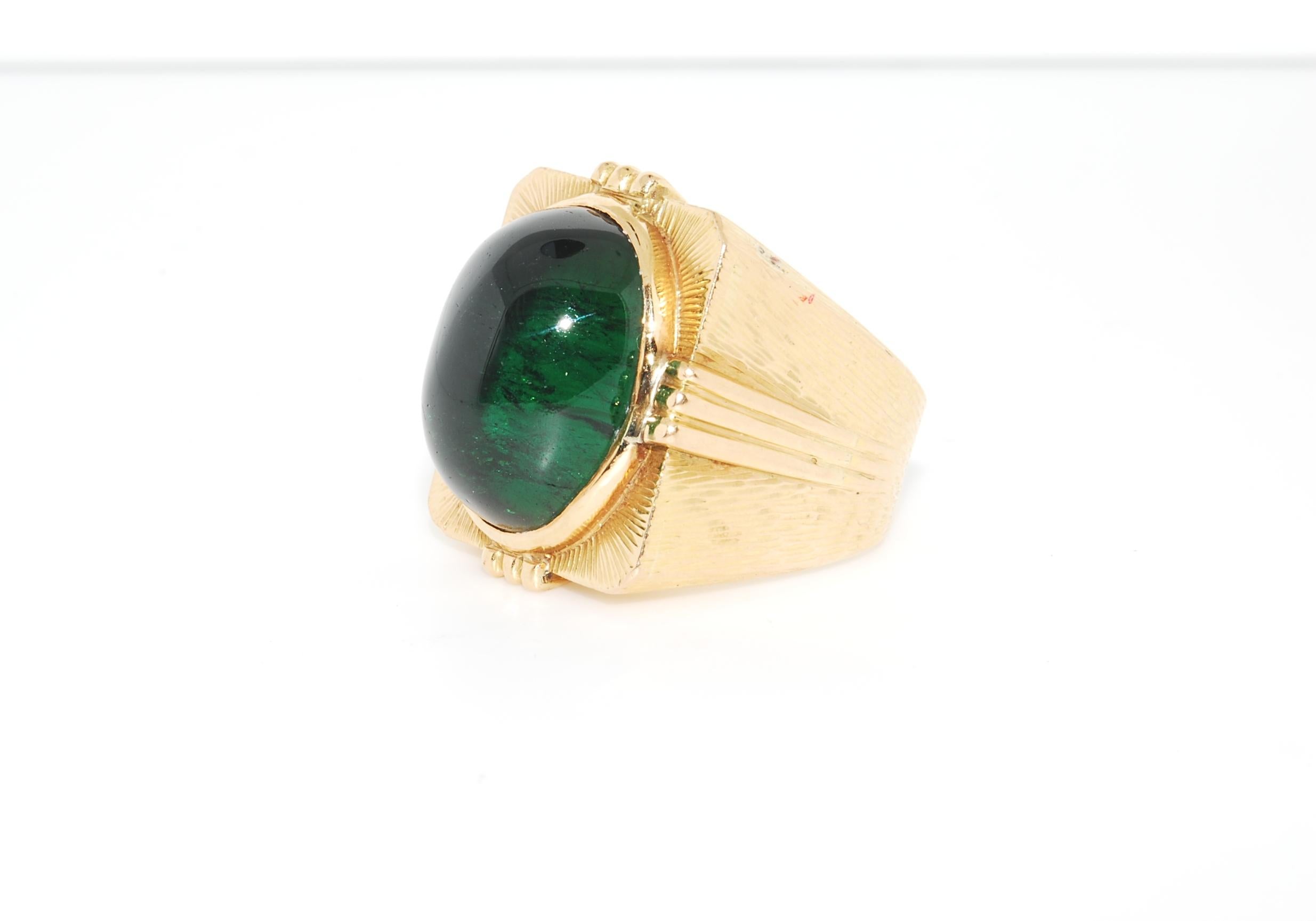 Dieser Solitär-Herrenring misst 25 x 23 mm. Der Turmalin wurde in Brasilien speziell für diesen Ring geschliffen. Im Sonnenlicht kommt das Grün richtig zur Geltung, ansonsten ist es ein dunkles Grün. 21 Gramm von 18 Karat Gelbgold. Dies ist für eine