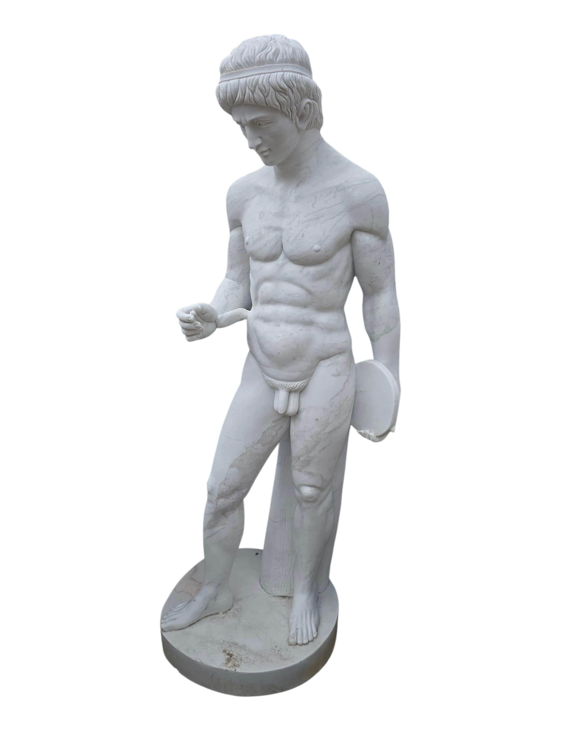 Scultura in marmo di grandi dimensioni che rappresenta il Discobolo, l'iconica figura greca immortalata in movimento mentre si prepara a lanciare il disco. Scolpito in Italia negli anni '70 in pregiato marmo bianco, questo pezzo si ispira alla