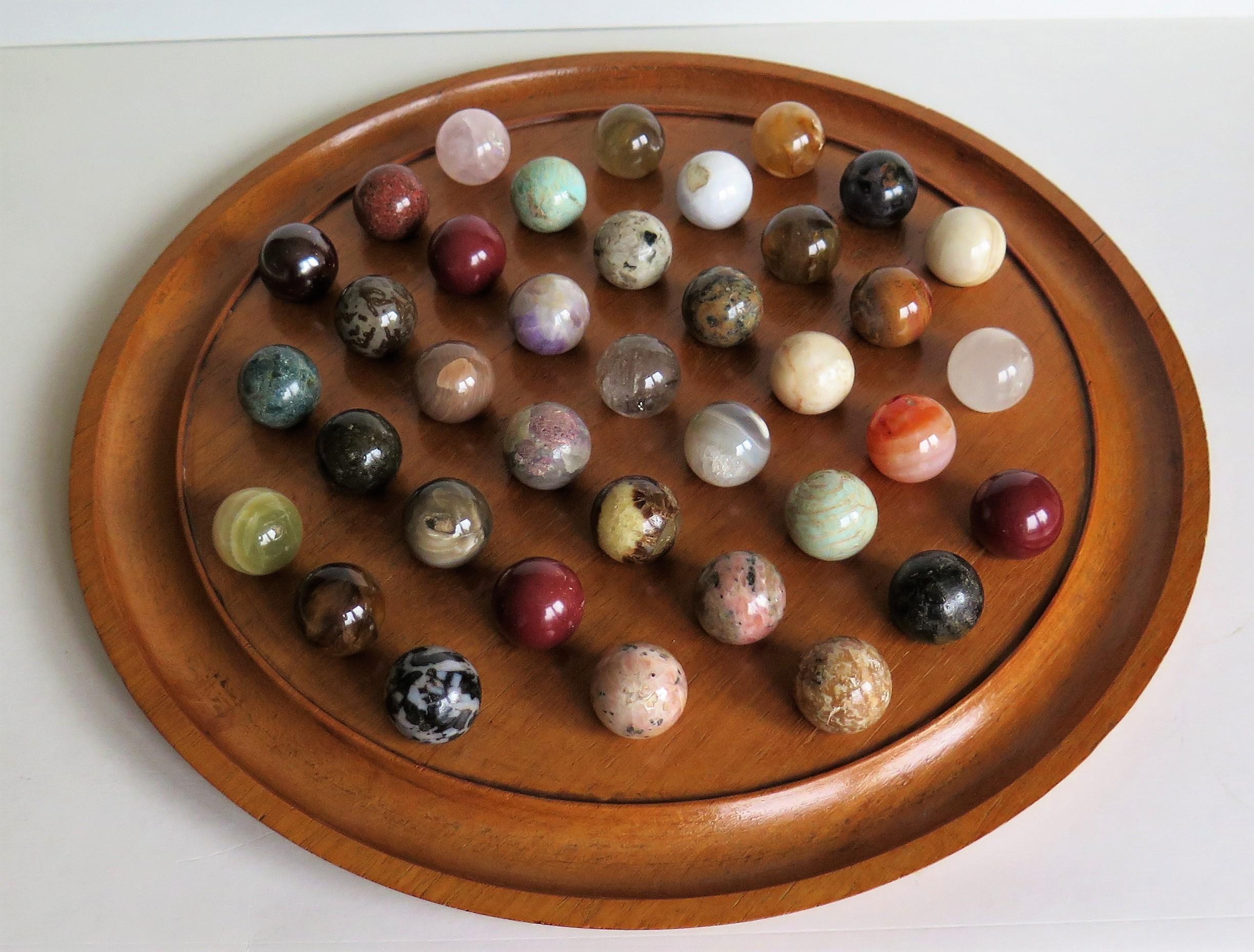 This is a complete board game of 37 hole marble solitaire with a large 13 inch diameter hardwood board and 37 beautiful individual agate stone and glass marbles, which we date to the late 19th century.

The circular turned board is made of