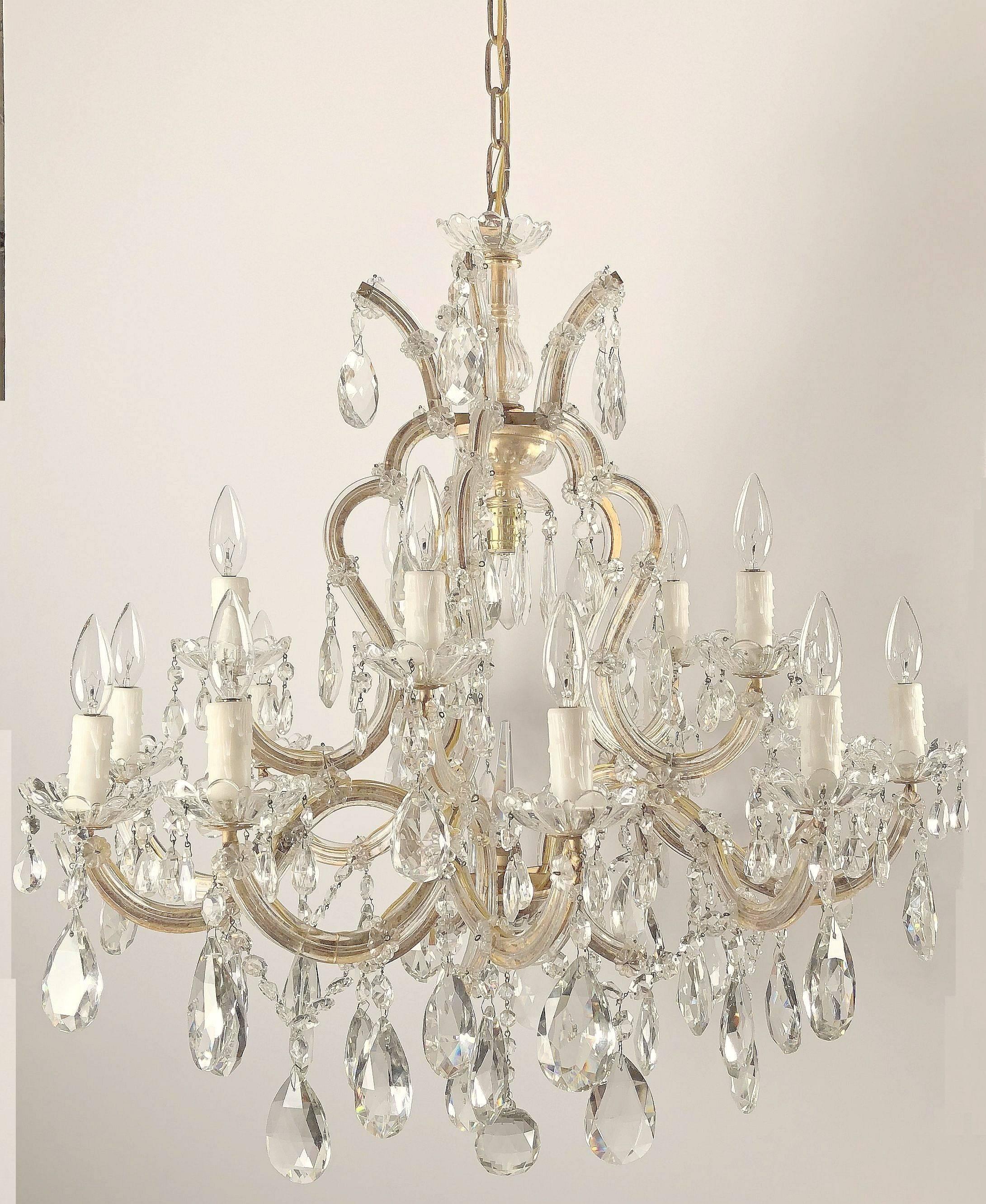 A lovely large Maria Theresa sixteen-light chandelier (or hanging fixture) of crystal, glass and gilt metal featuring serpentine arms, each candle light with dangling pendants and decorative bobeche.

Measures: 35 inches diameter.

U.S.-wired