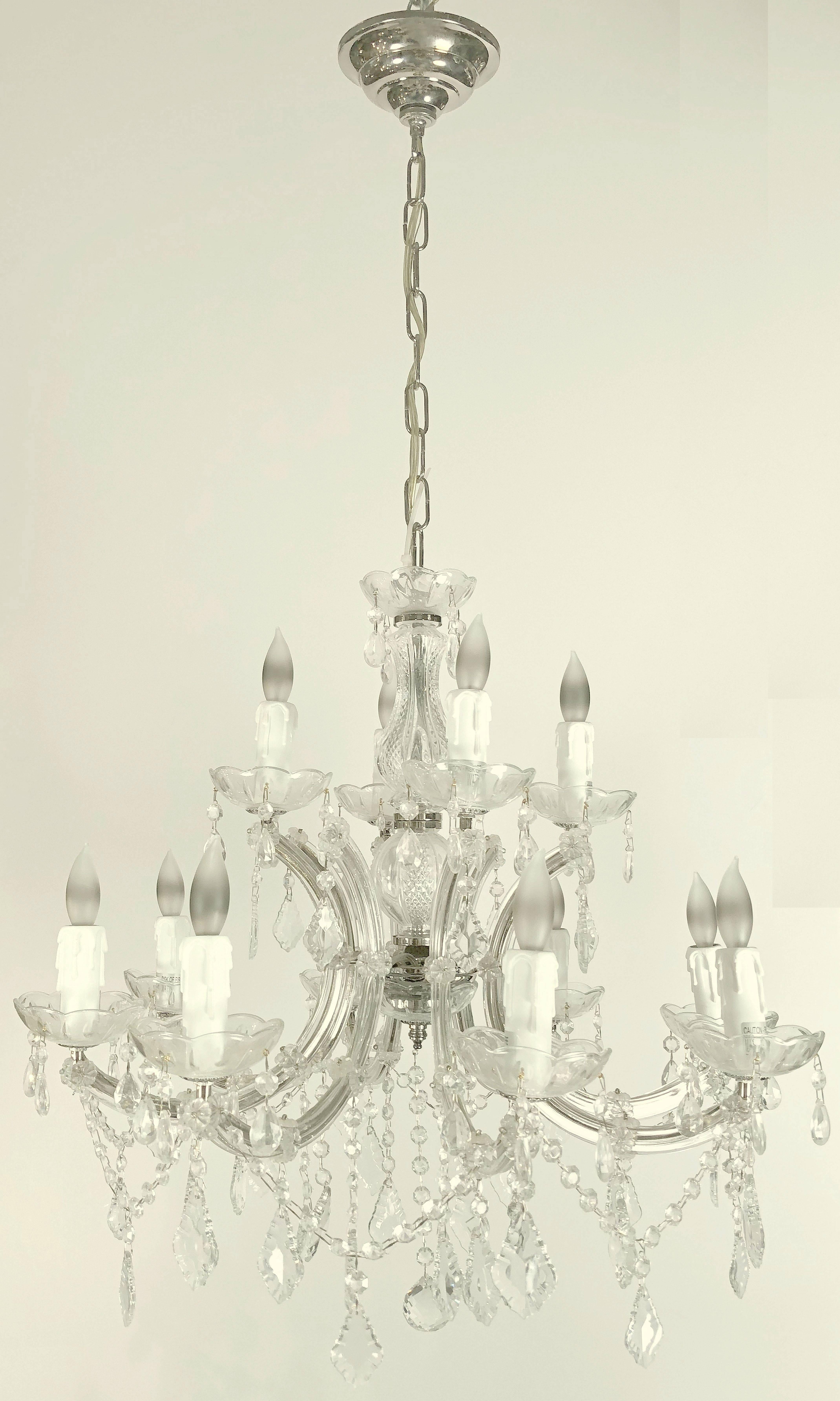 A lovely large Maria Theresa twelve-light chandelier (or hanging fixture) of crystal, glass and chromed metal featuring serpentine arms, each candle light with dangling pendants and decorative bobeche.

Measures: 24 inches diameter.

U.S.-wired