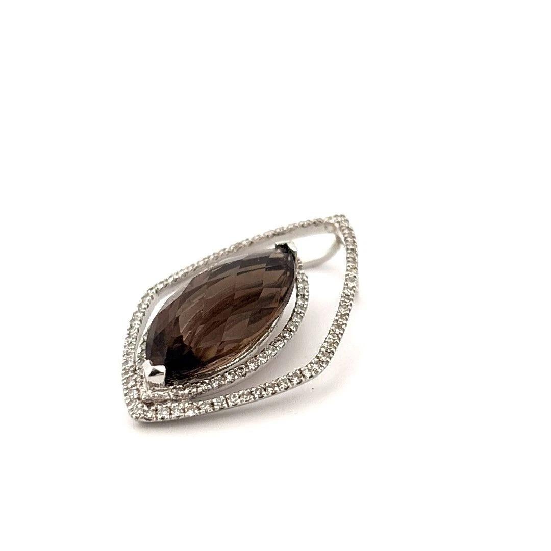 Offered is a bold and uniquely elegant 14K white gold pendant featuring a large marquise-cut smoky quartz with a checkerboard faceted crown, accented by over 100 round single-cut diamonds in a modern, geometric design. The center stone measures
