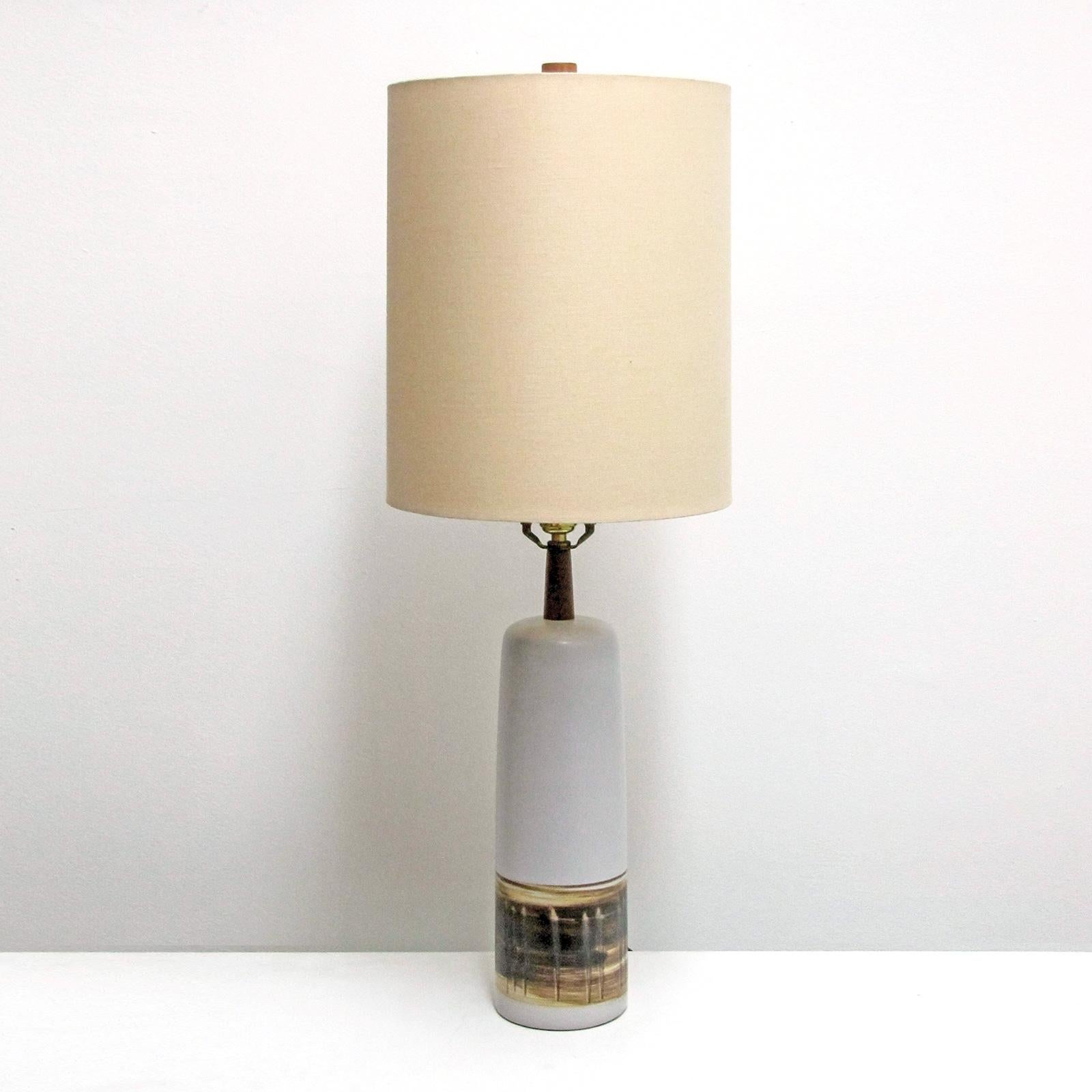 Large-scale soft gray and white satin finish ceramic table lamp by Marshall Studios, broad textured band along the lower third, Gordon Martz's signature details of walnut necks and finial, signed, wired for US standards, one E27 socket, max. wattage