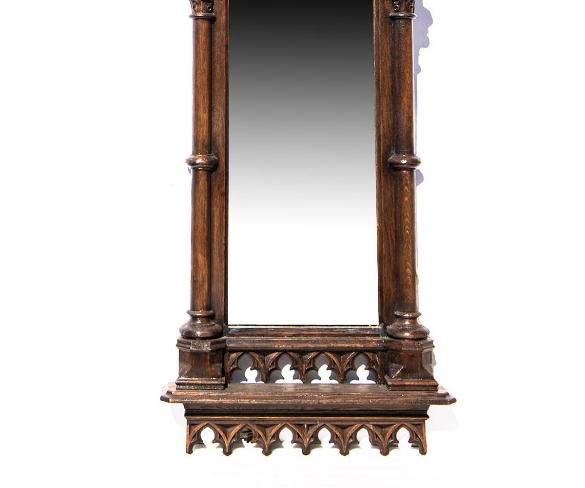Offered is this extremely tall antique, 17th century Gothic wood frame that has been carefully restored and modified to add a new mirror. This piece likely held a piece of stained glass or an oil painting in a church. The rustic frame has all of the