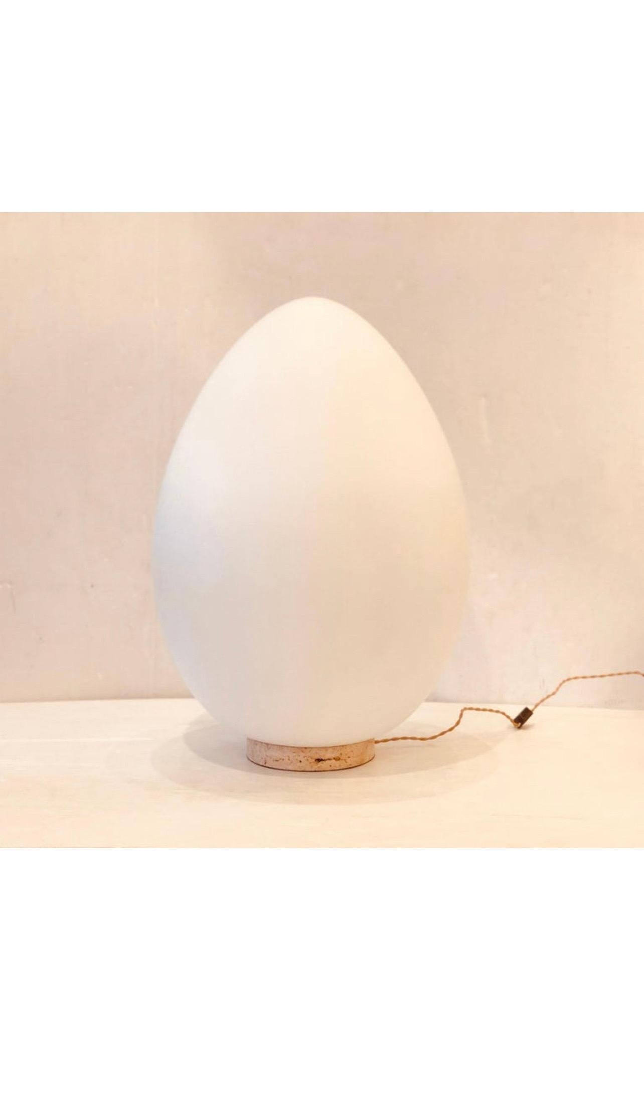 An amazing extra large egg-shaped glass, sitting on a solid travertine base freshly rewired, with a cloth cord the lamp is absolutely gorgeous and very rare it takes a regular lightbulb up to 100 watts, with no chips or cracks. Ben Swildens for