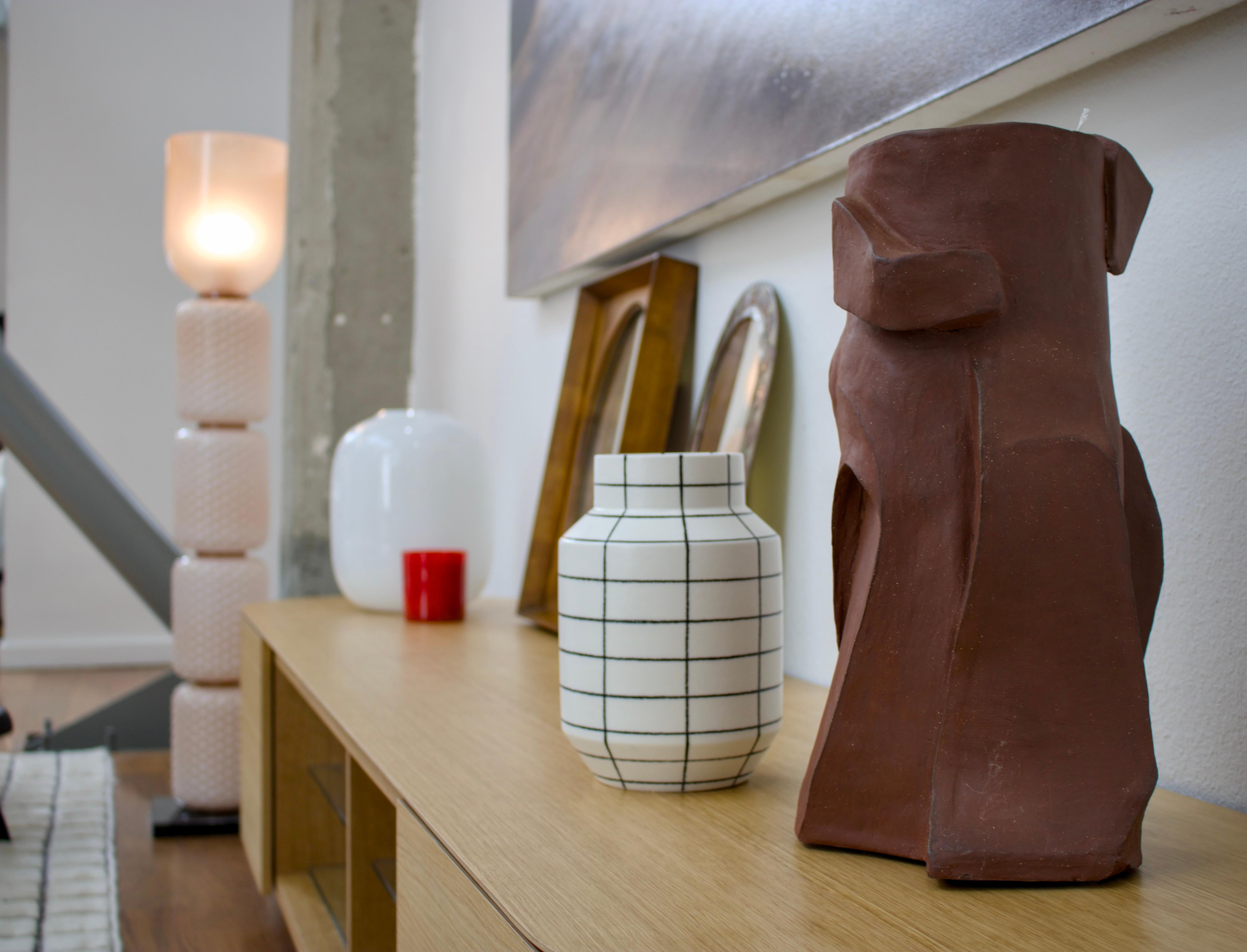 Questa sorprendente scultura in terracotta incarna l'essenza del modernismo di metà secolo con la sua audace forma astratta e gli spazi negativi. La costruzione in argilla naturale celebra il minimalismo organico attraverso le sue curve fluide e le