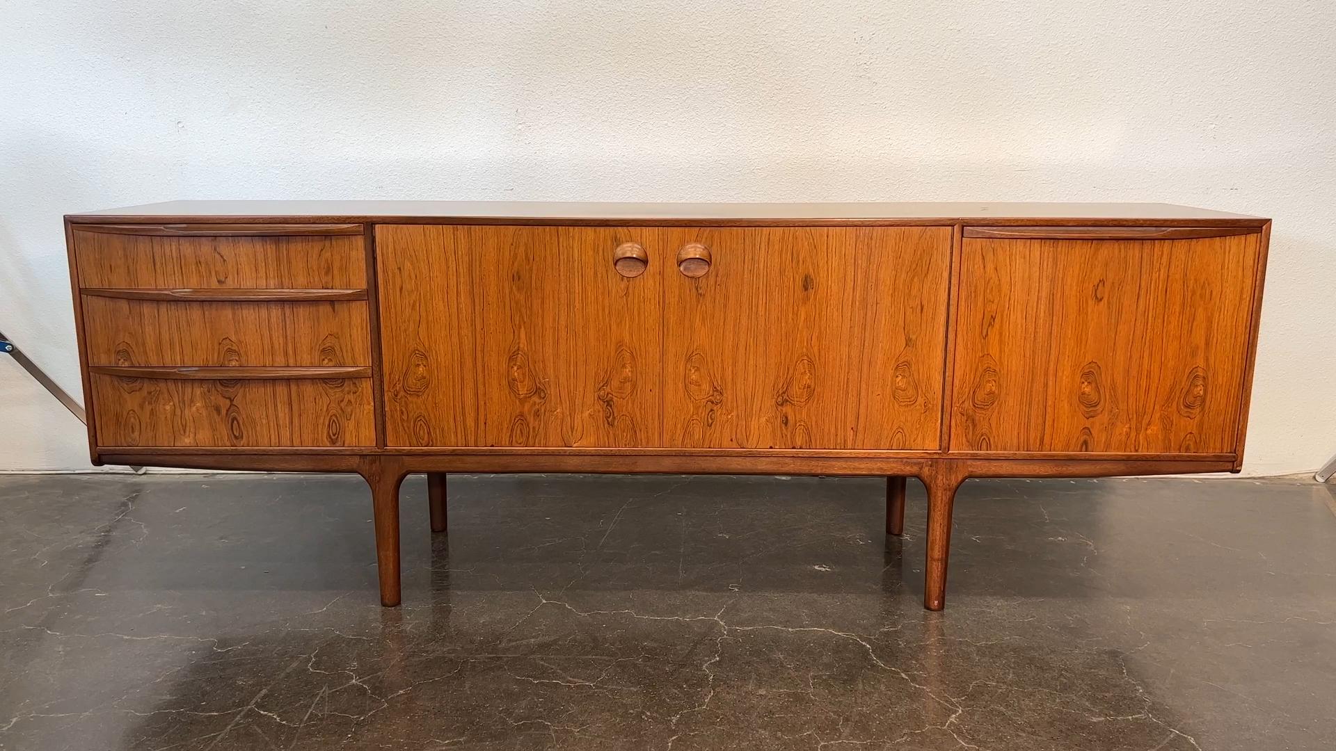 Herkunft: Schottland
Designer: Val Rossi
Hersteller: A.H. McIntosh
Epoche: 1960er Jahre
MATERIALIEN: Palisanderholz
Abmessungen: 84″ breit x 18″ tief x 30″ hoch