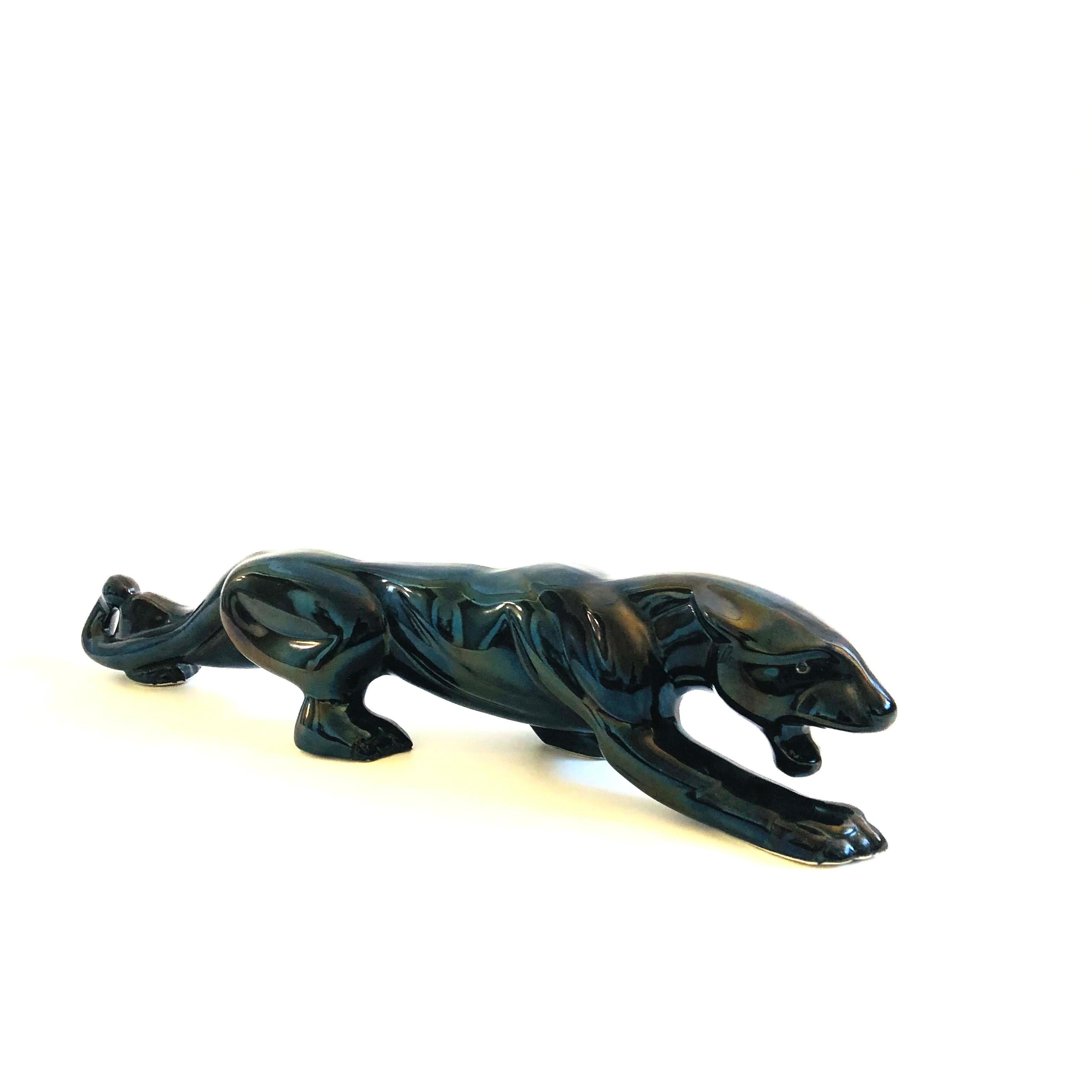 A large mid century black panther sculpture. Made of ceramic and finished in a glossy black glaze. A great sculptural statement piece.

