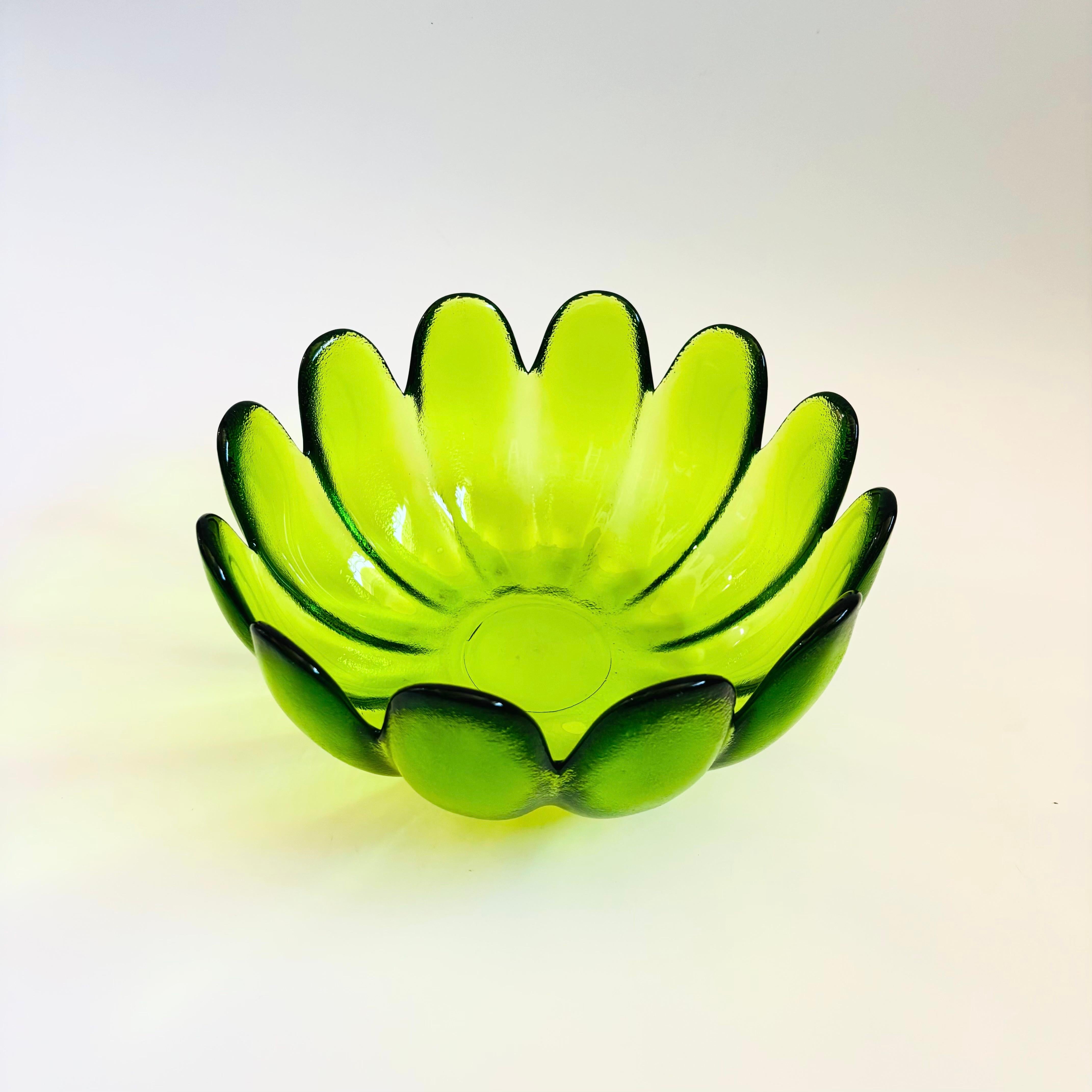 A large mid century glass lotus shaped bowl by Indiana Glass. Beautiful vibrant green color to the glass. Slightly textured exterior and smooth interior. Made of thick heavy glass. A beautiful piece perfect for serving salads or using as a fruit